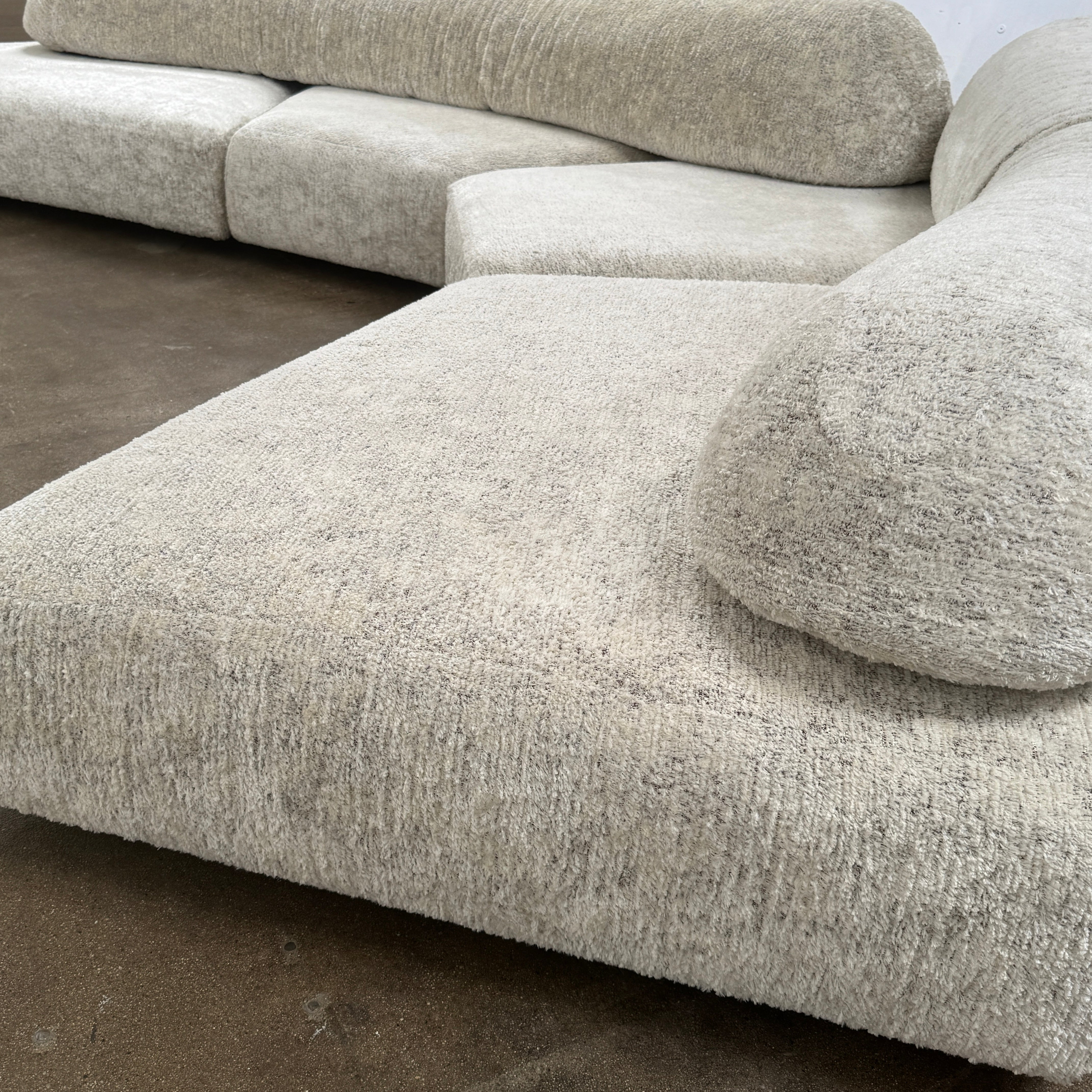The Edra On The Rocks 4 piece Modular Sofa by Edra is a modern, light gray L-shaped sofa with customizable seating, featuring low rounded backrests and wide flat cushions, shown on a plain white background.