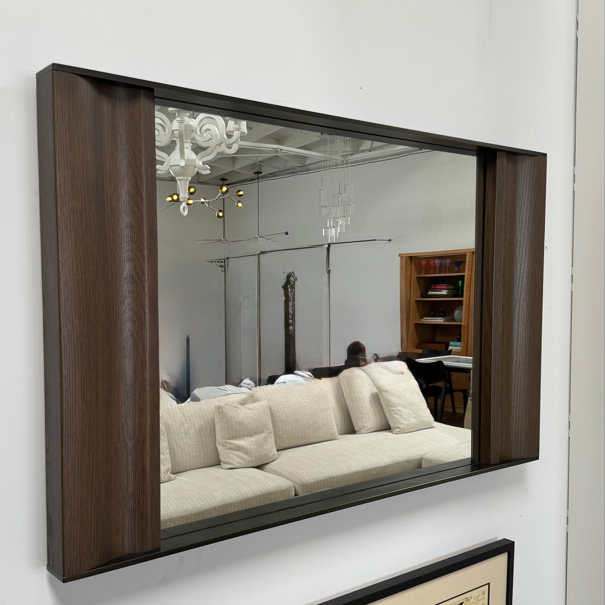 The Holly Hunt Cinema Mirror by Holly Hunt features a rectangular wooden frame, reflecting a grid window, pendant light, and interior, with a luxurious style true to its name.
