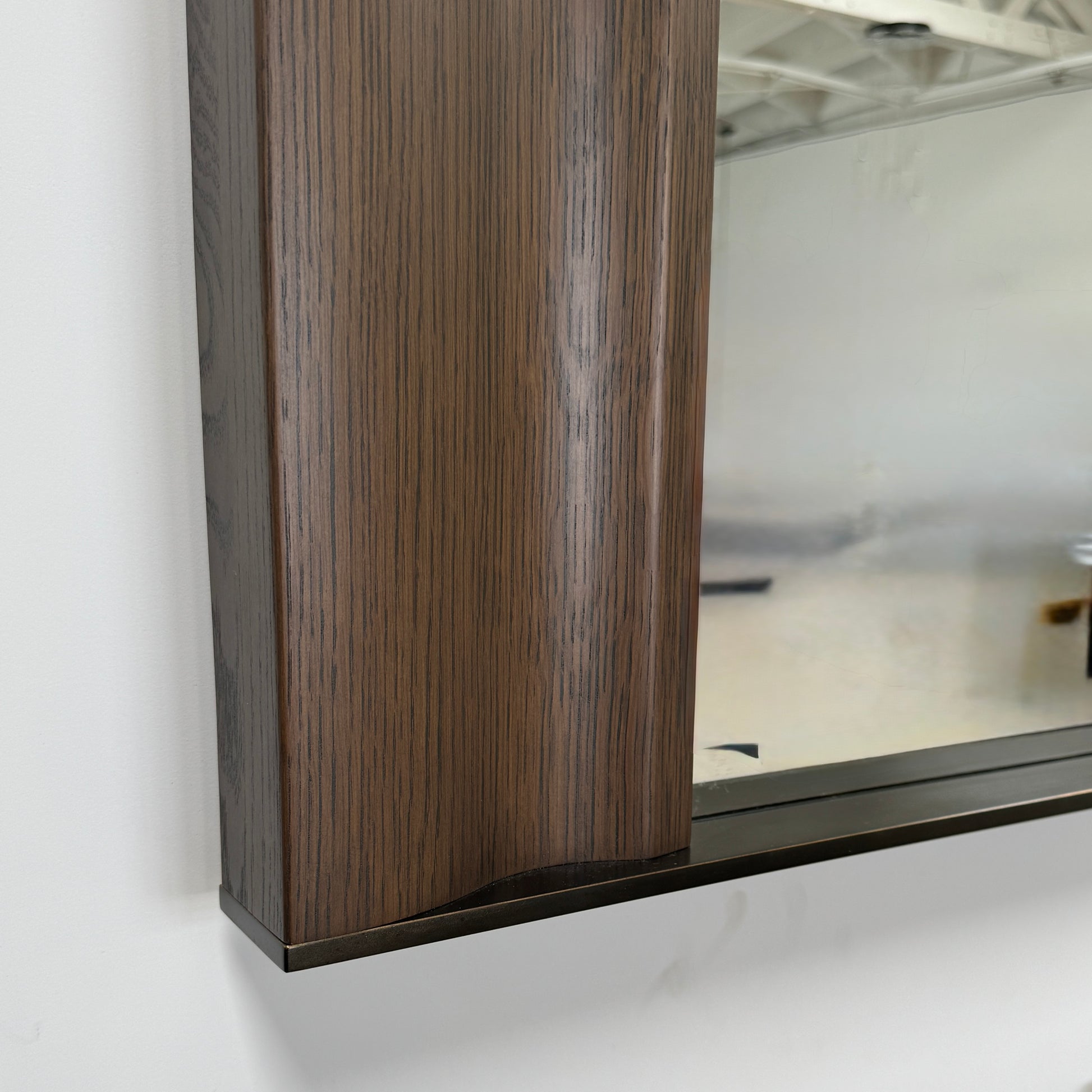 The Holly Hunt Cinema Mirror by Holly Hunt features a rectangular wooden frame, reflecting a grid window, pendant light, and interior, with a luxurious style true to its name.