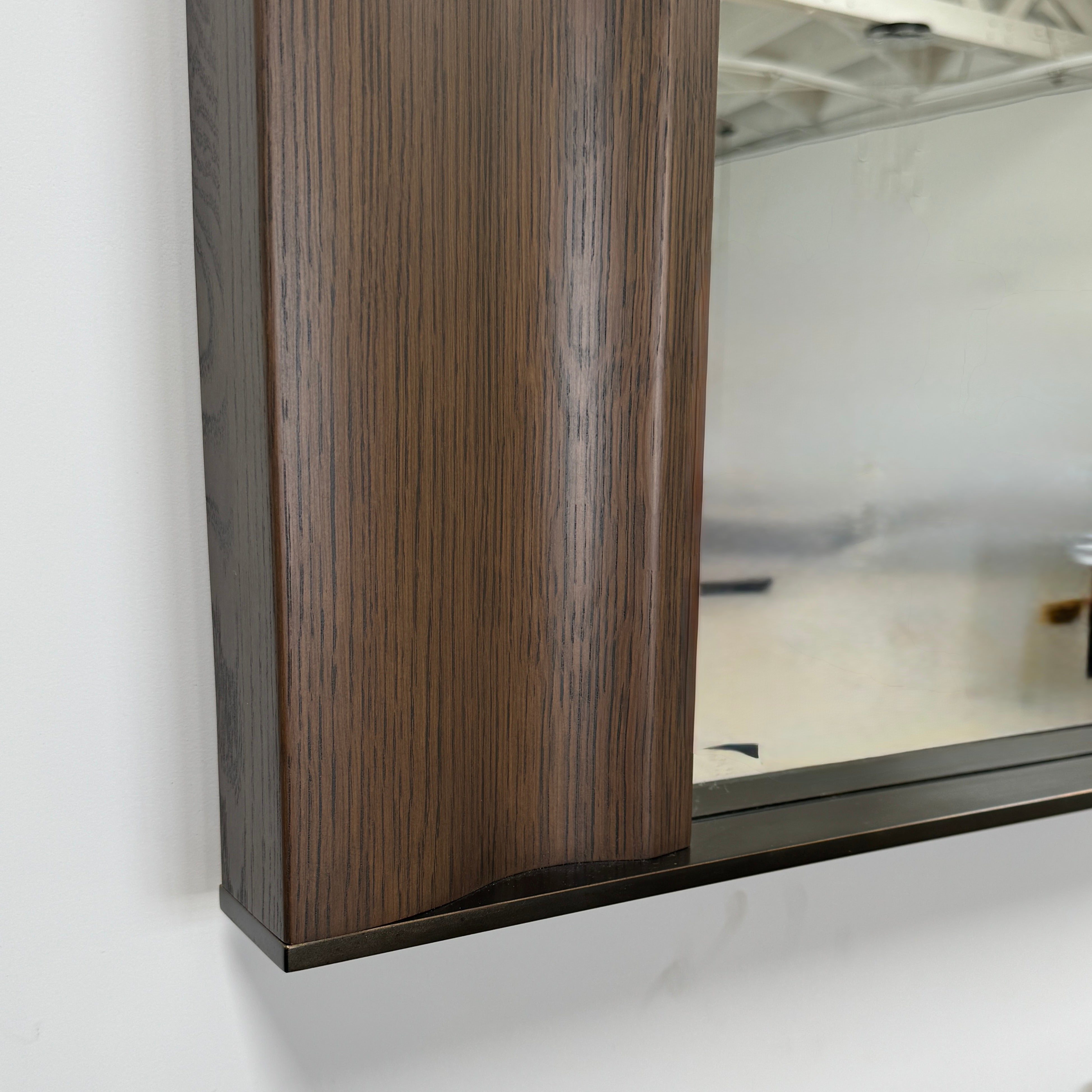 The Holly Hunt Cinema Mirror by Holly Hunt features a rectangular wooden frame, reflecting a grid window, pendant light, and interior, with a luxurious style true to its name.