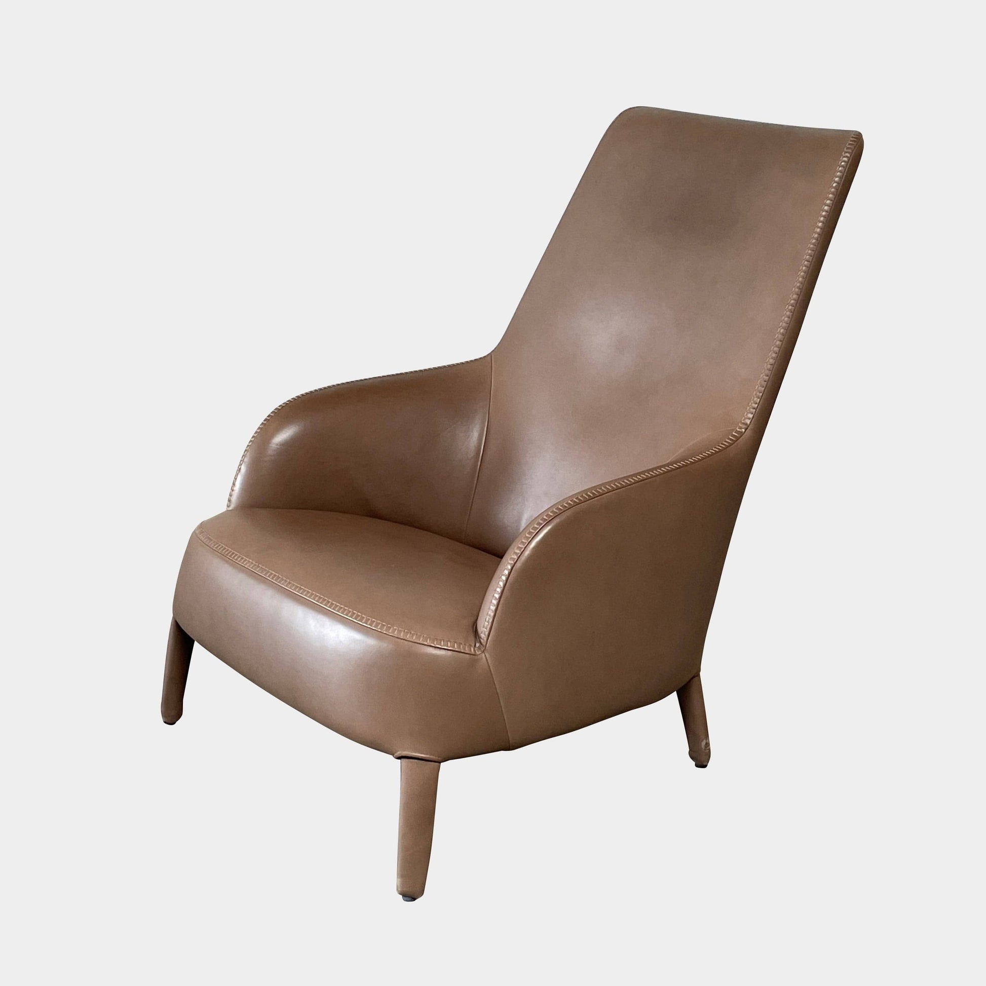 A brown leather armchair with a high backrest and curved arms, showcasing classic leather upholstery, is paired with a matching ottoman, both resting on thin legs. This sophisticated set embodies the elegant style of Maxalto's Maxalto Febo High Back Lounge Chair and Ottoman collection.