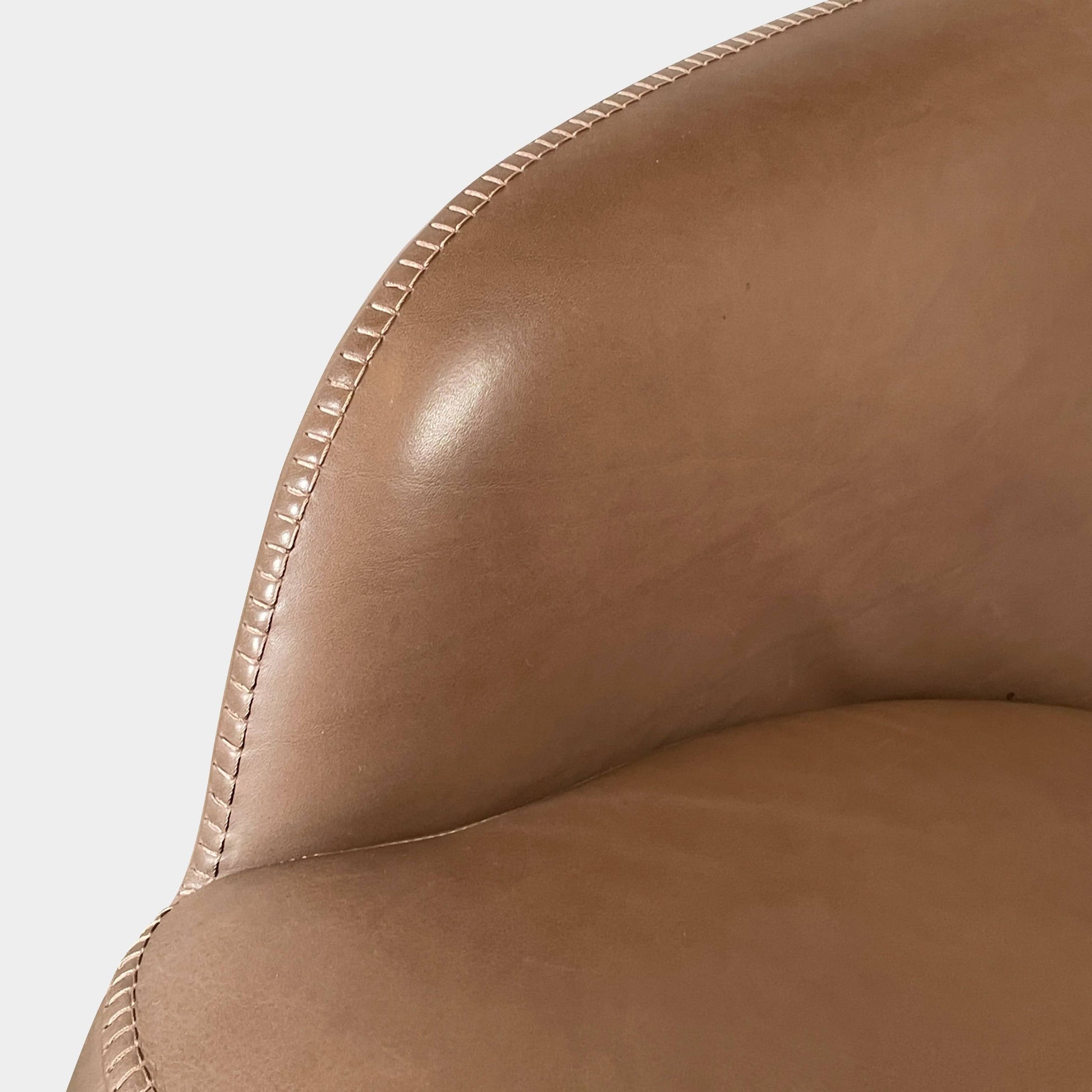 A brown leather armchair with a high backrest and curved arms, showcasing classic leather upholstery, is paired with a matching ottoman, both resting on thin legs. This sophisticated set embodies the elegant style of Maxalto's Maxalto Febo High Back Lounge Chair and Ottoman collection.