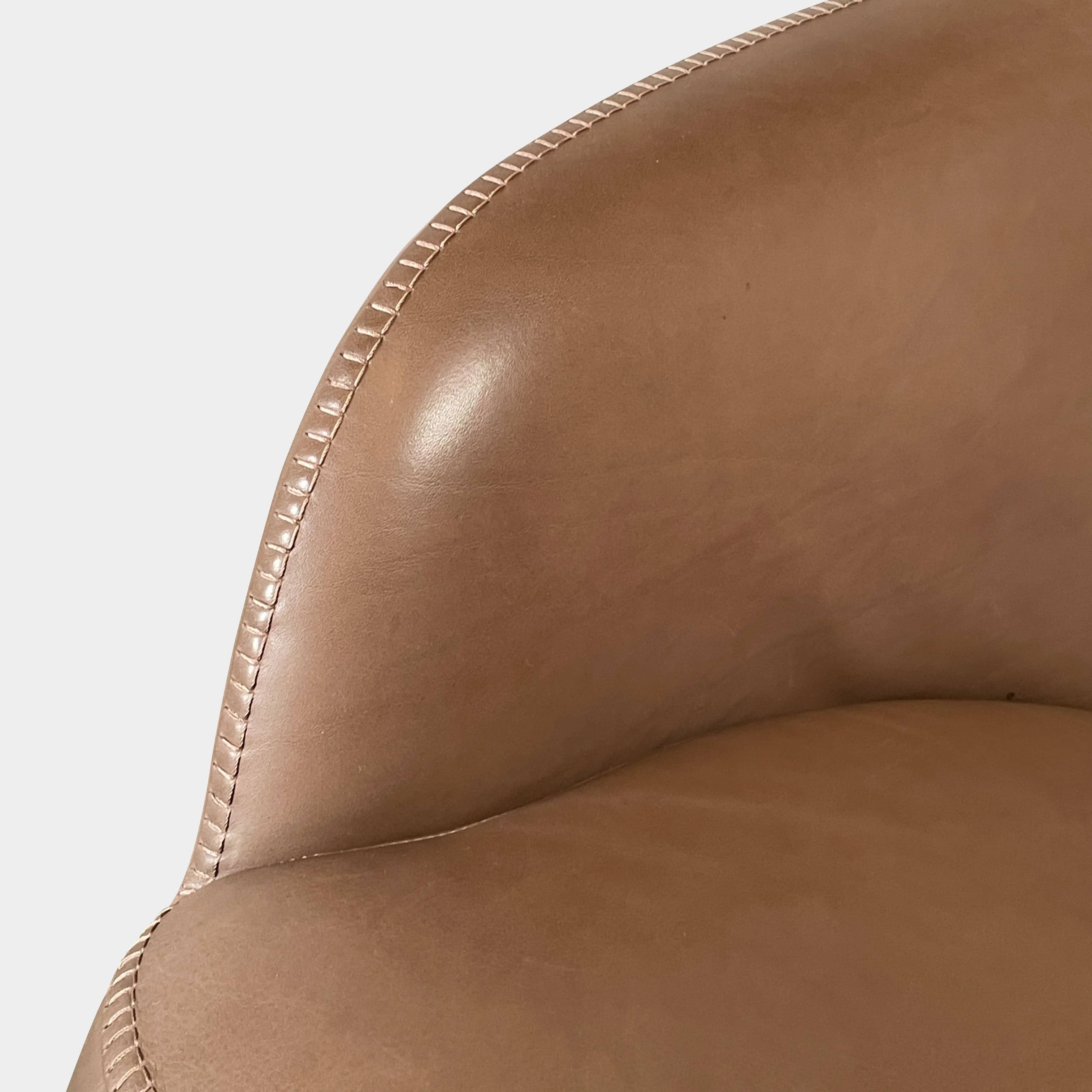 A brown leather armchair with a high backrest and curved arms, showcasing classic leather upholstery, is paired with a matching ottoman, both resting on thin legs. This sophisticated set embodies the elegant style of Maxalto's Maxalto Febo High Back Lounge Chair and Ottoman collection.
