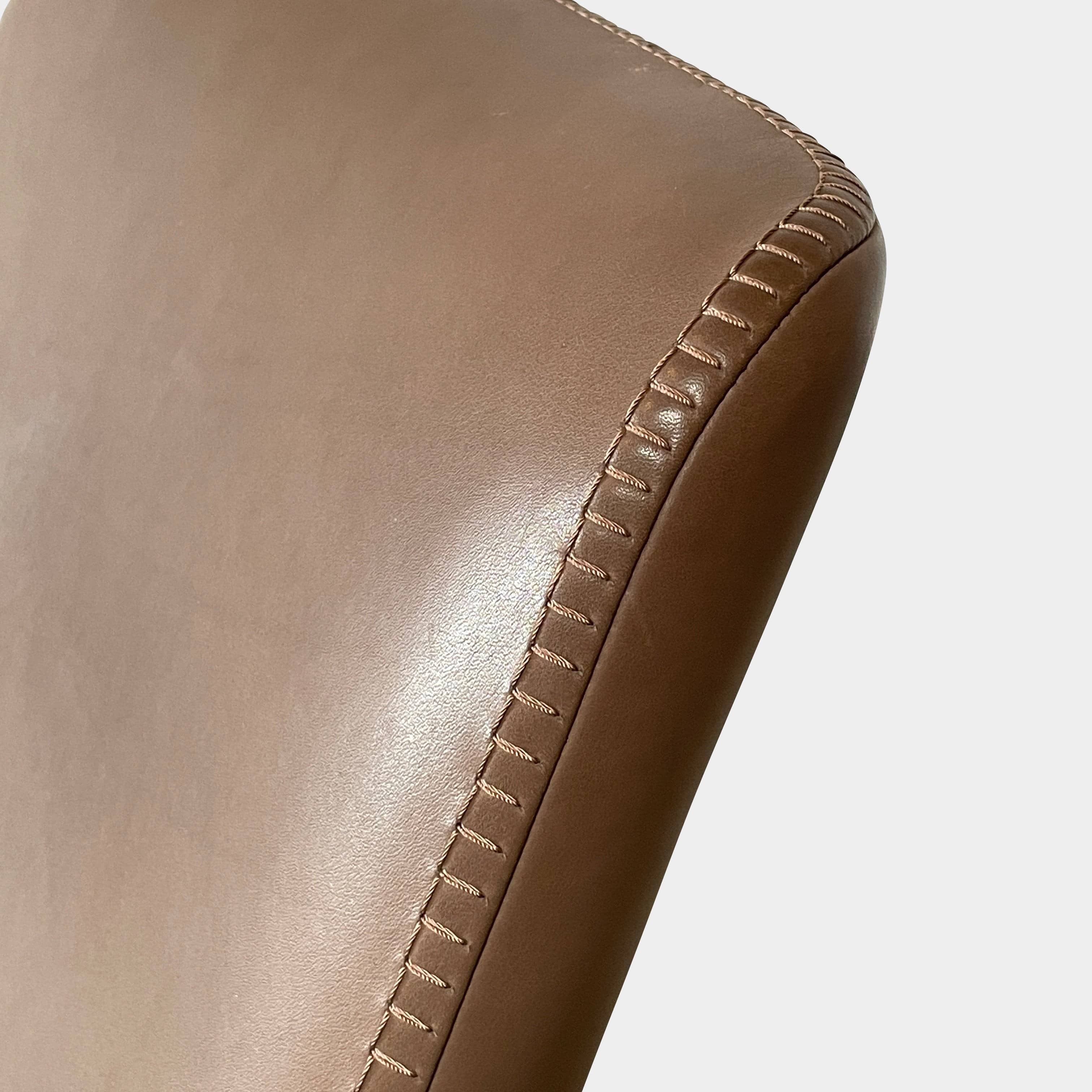 A brown leather armchair with a high backrest and curved arms, showcasing classic leather upholstery, is paired with a matching ottoman, both resting on thin legs. This sophisticated set embodies the elegant style of Maxalto's Maxalto Febo High Back Lounge Chair and Ottoman collection.