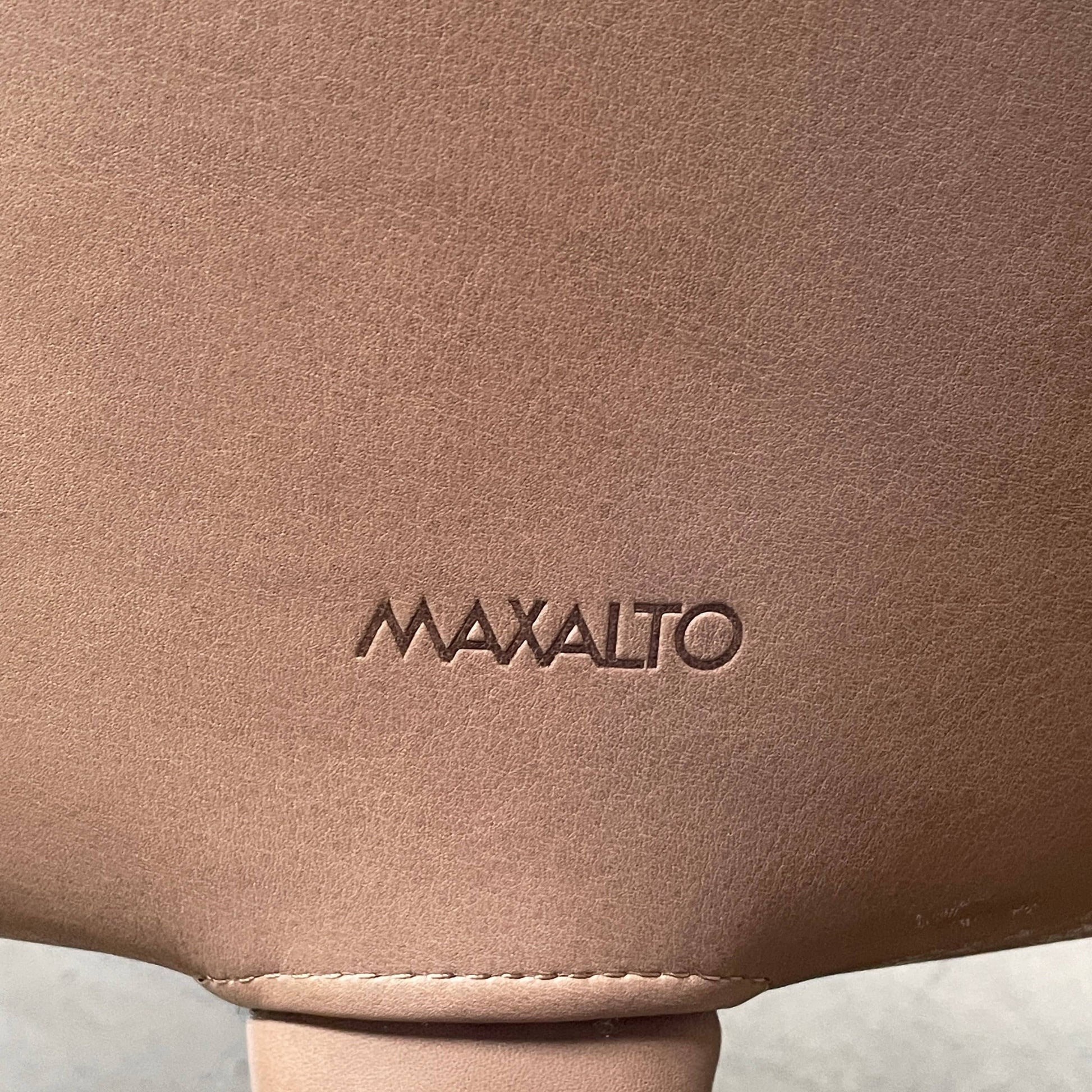 A brown leather armchair with a high backrest and curved arms, showcasing classic leather upholstery, is paired with a matching ottoman, both resting on thin legs. This sophisticated set embodies the elegant style of Maxalto's Maxalto Febo High Back Lounge Chair and Ottoman collection.