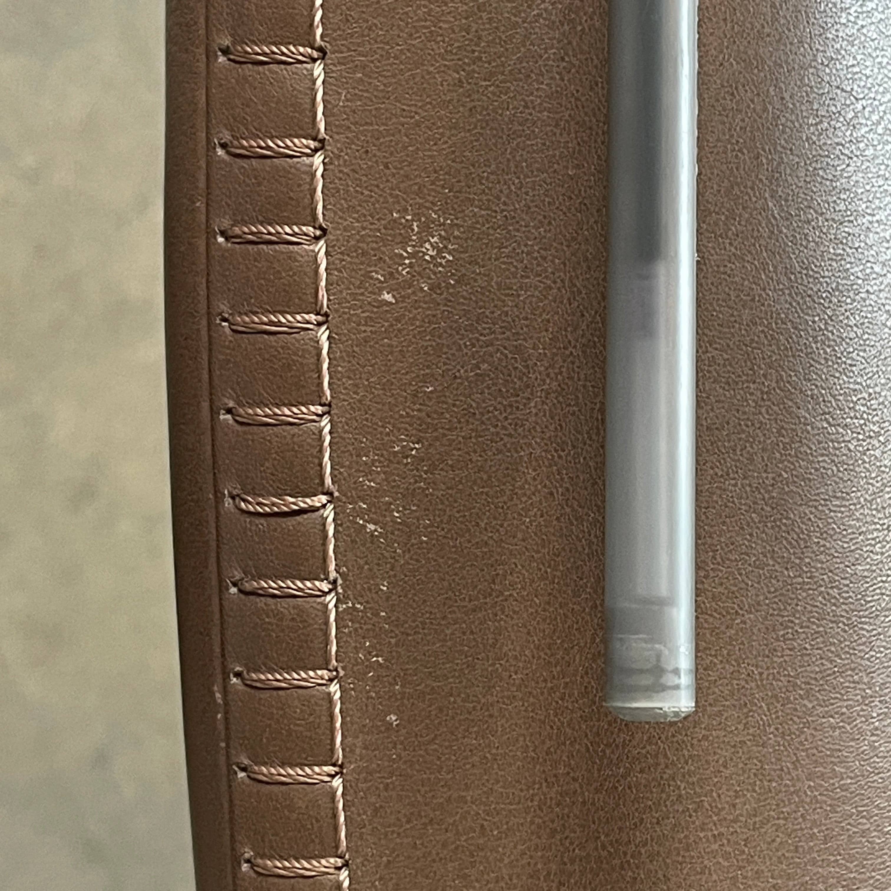 A brown leather armchair with a high backrest and curved arms, showcasing classic leather upholstery, is paired with a matching ottoman, both resting on thin legs. This sophisticated set embodies the elegant style of Maxalto's Maxalto Febo High Back Lounge Chair and Ottoman collection.