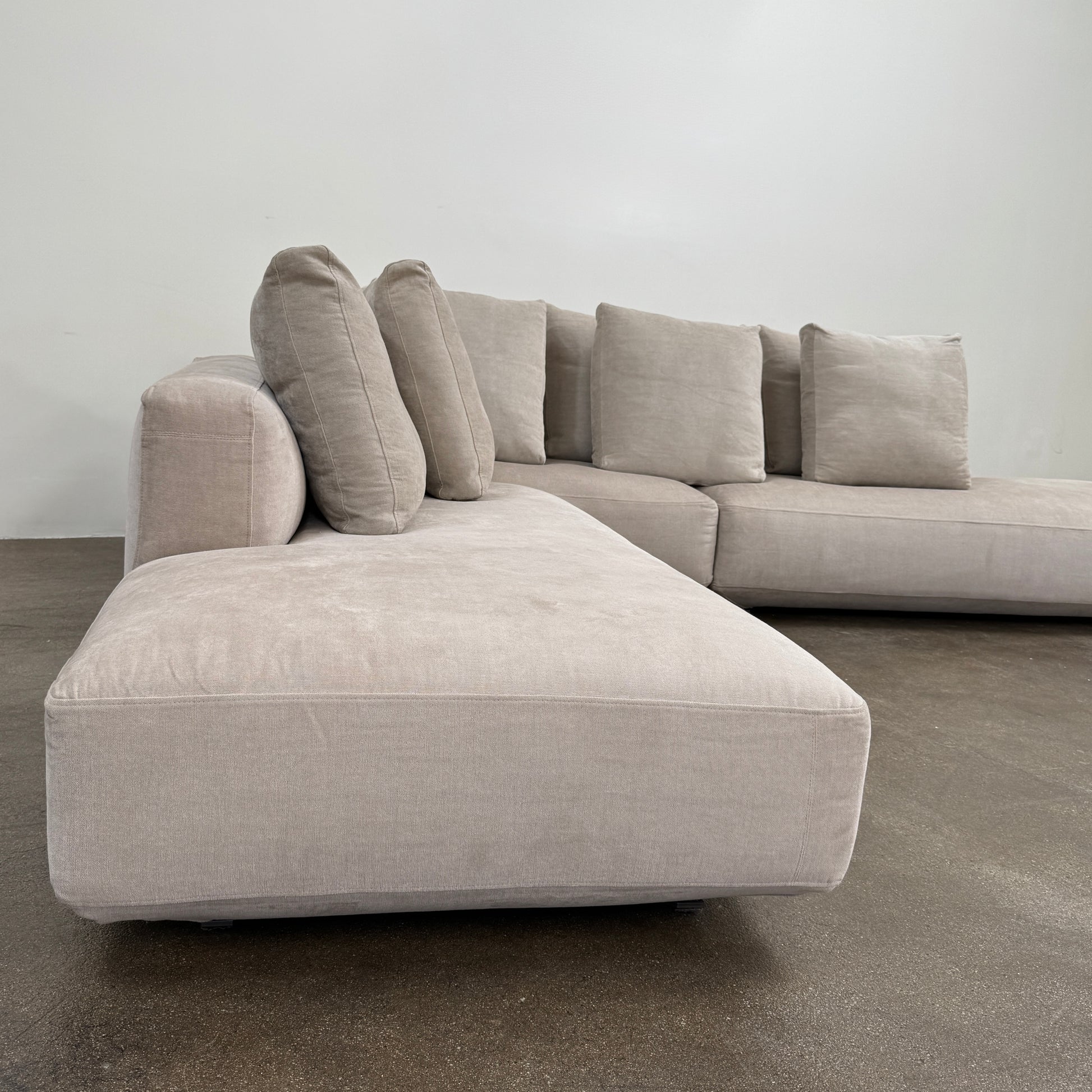 The Zanotta Pianoalto 3 Piece Sectional by Zanotta features light gray brushed cotton blend upholstery and five matching back cushions for ergonomic support, shown against a plain white background.
