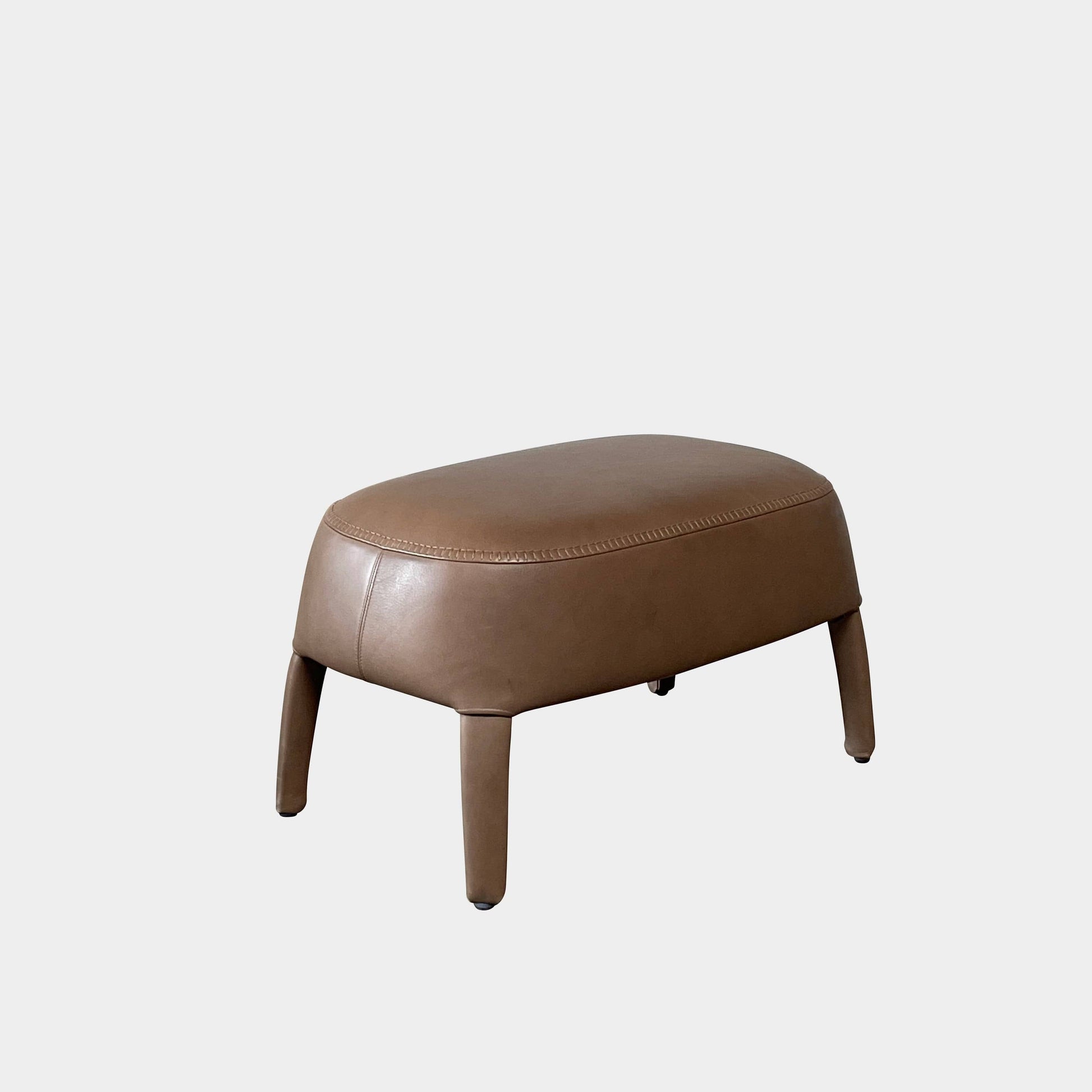 A brown leather armchair with a high backrest and curved arms, showcasing classic leather upholstery, is paired with a matching ottoman, both resting on thin legs. This sophisticated set embodies the elegant style of Maxalto's Maxalto Febo High Back Lounge Chair and Ottoman collection.