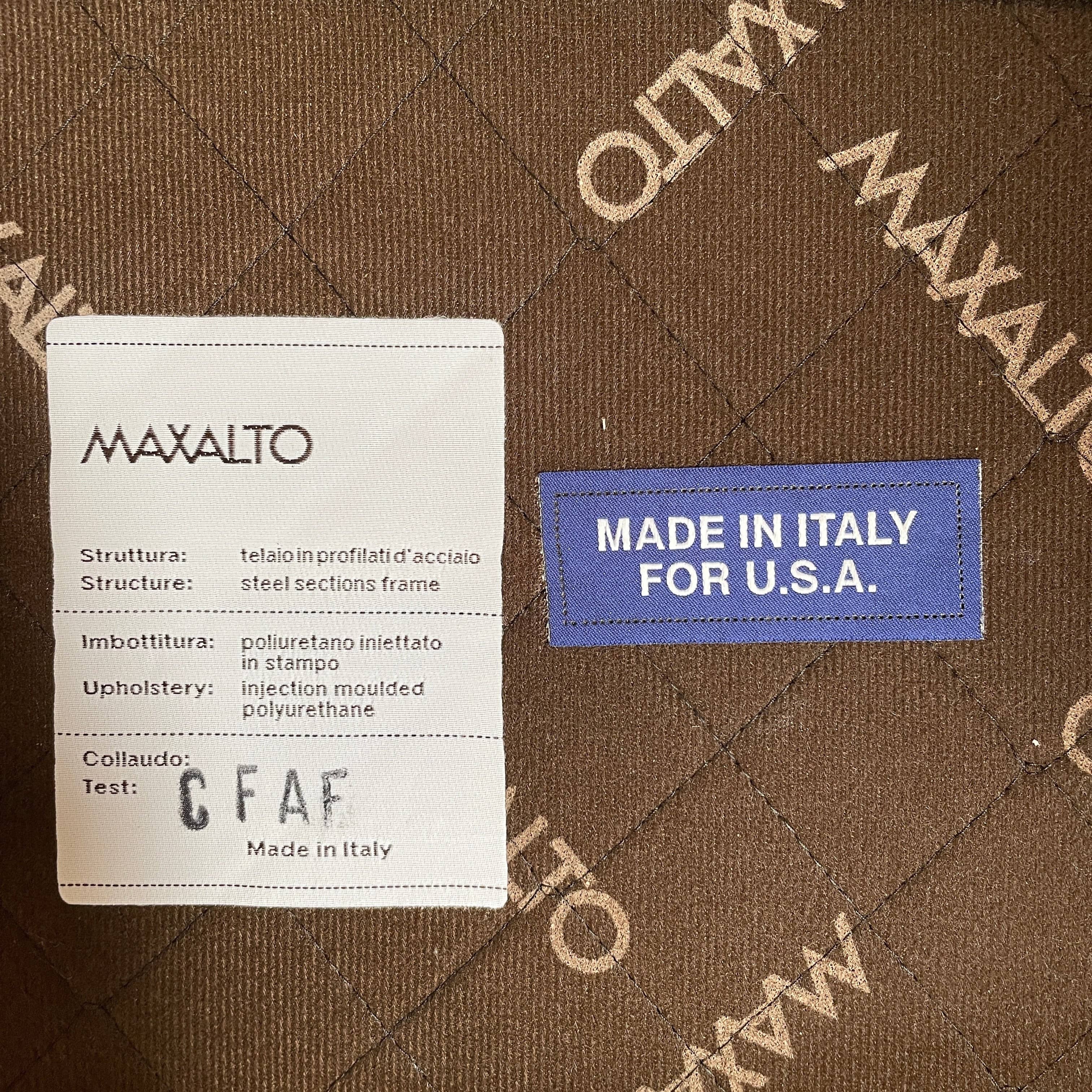 A brown leather armchair with a high backrest and curved arms, showcasing classic leather upholstery, is paired with a matching ottoman, both resting on thin legs. This sophisticated set embodies the elegant style of Maxalto's Maxalto Febo High Back Lounge Chair and Ottoman collection.