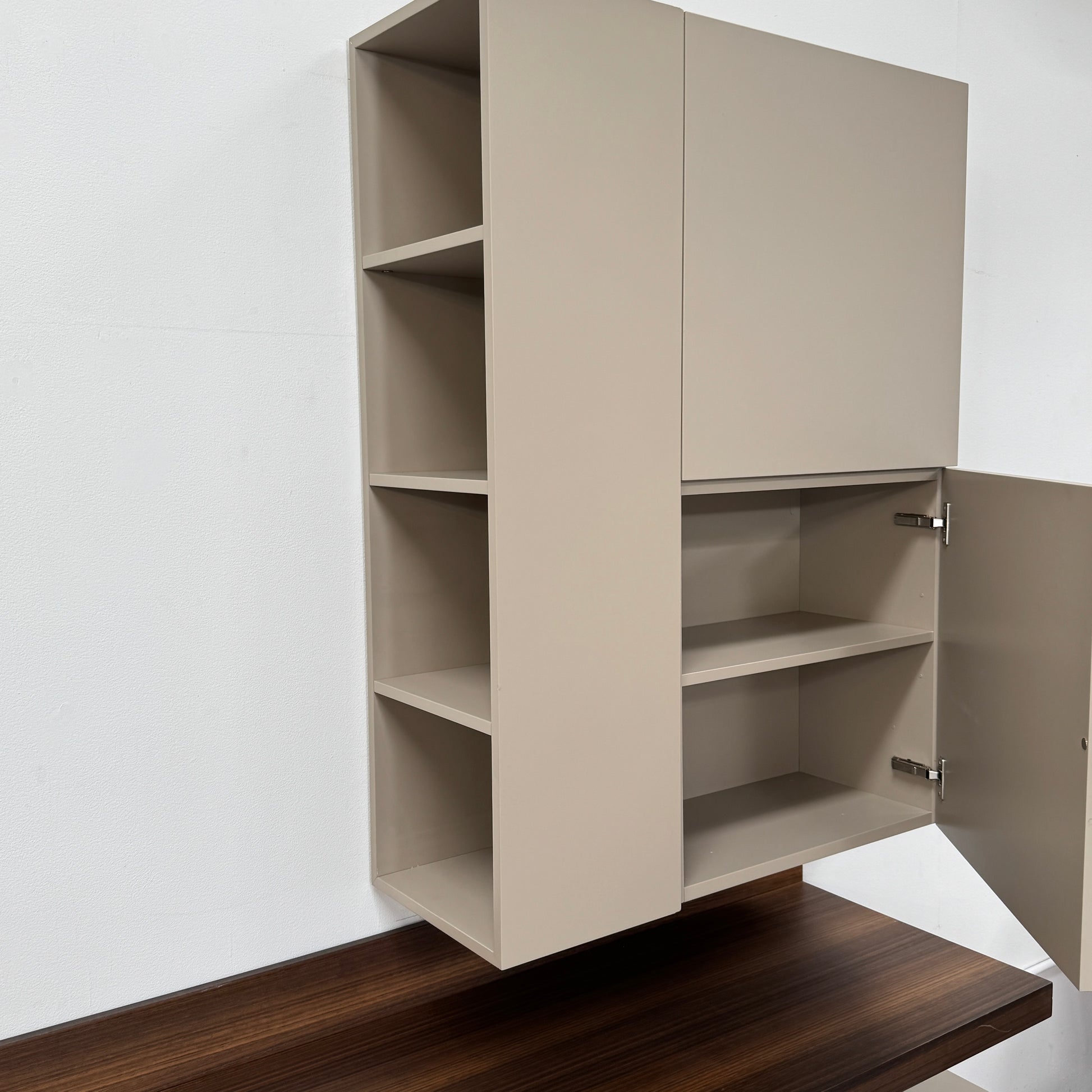 The Molteni & C Fortepiano Wall-mounted Desk System features a long wooden shelf, beige storage cabinets, and drawers for a sleek, modern look against a white wall.