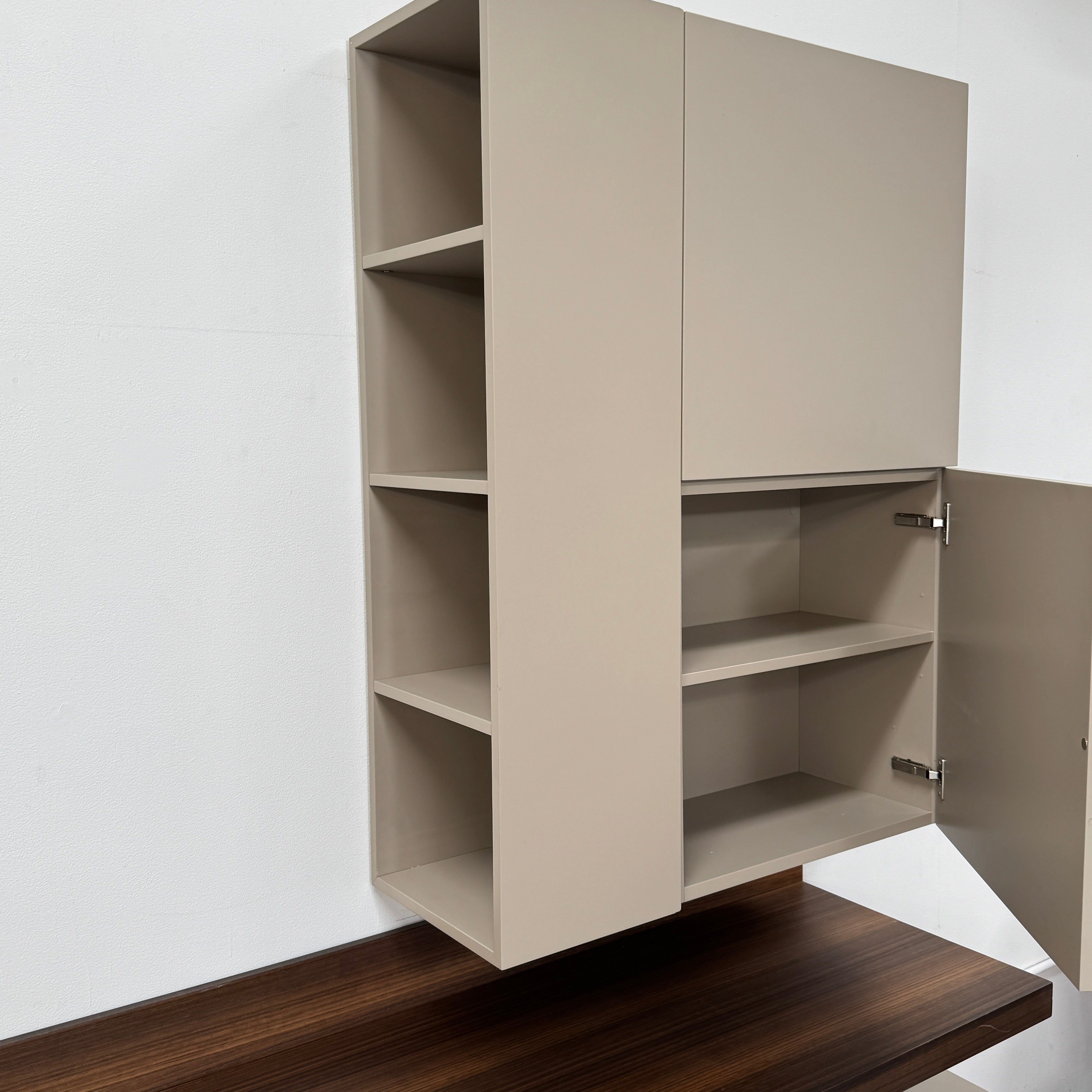 The Molteni & C Fortepiano Wall-mounted Desk System features a long wooden shelf, beige storage cabinets, and drawers for a sleek, modern look against a white wall.