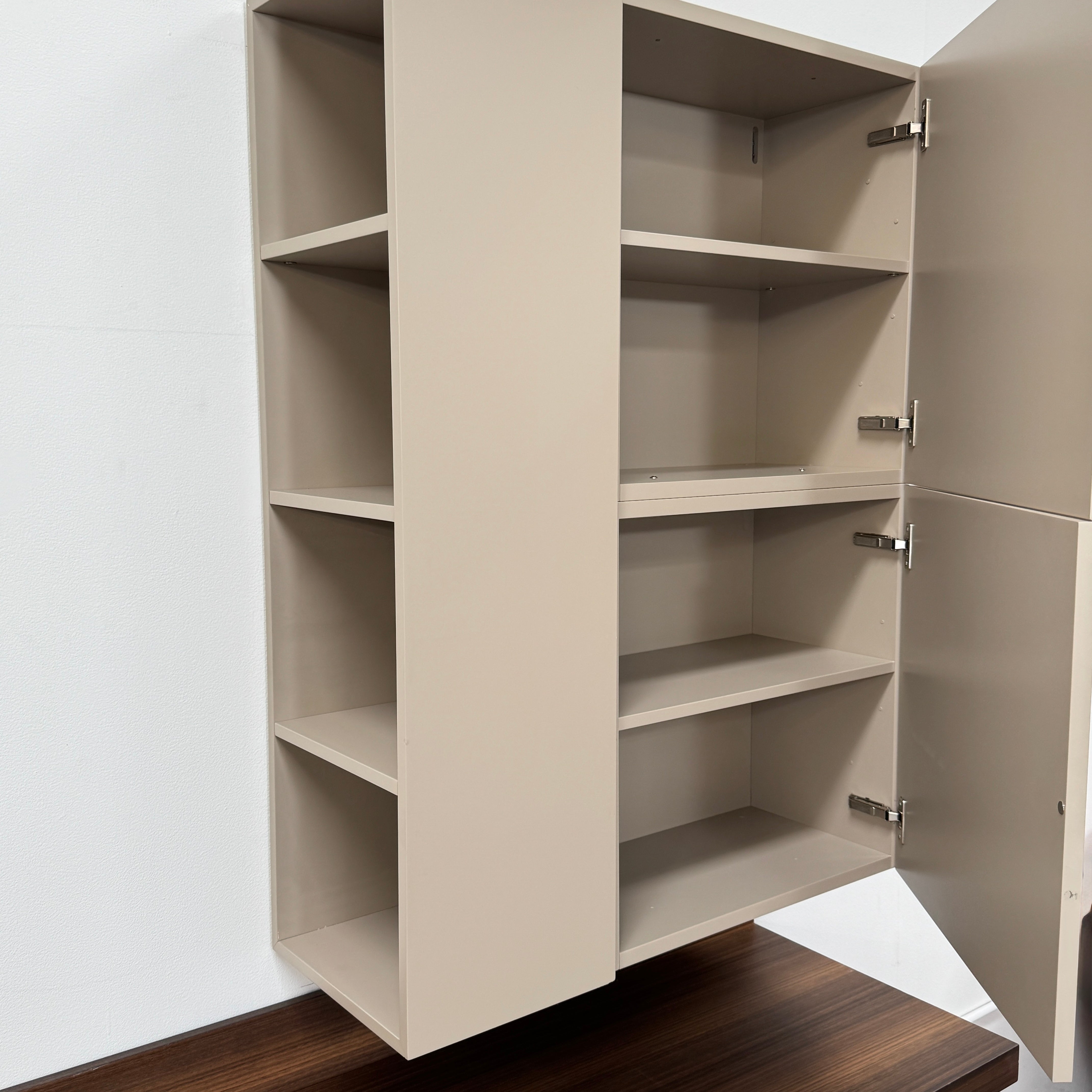 The Molteni & C Fortepiano Wall-mounted Desk System features a long wooden shelf, beige storage cabinets, and drawers for a sleek, modern look against a white wall.
