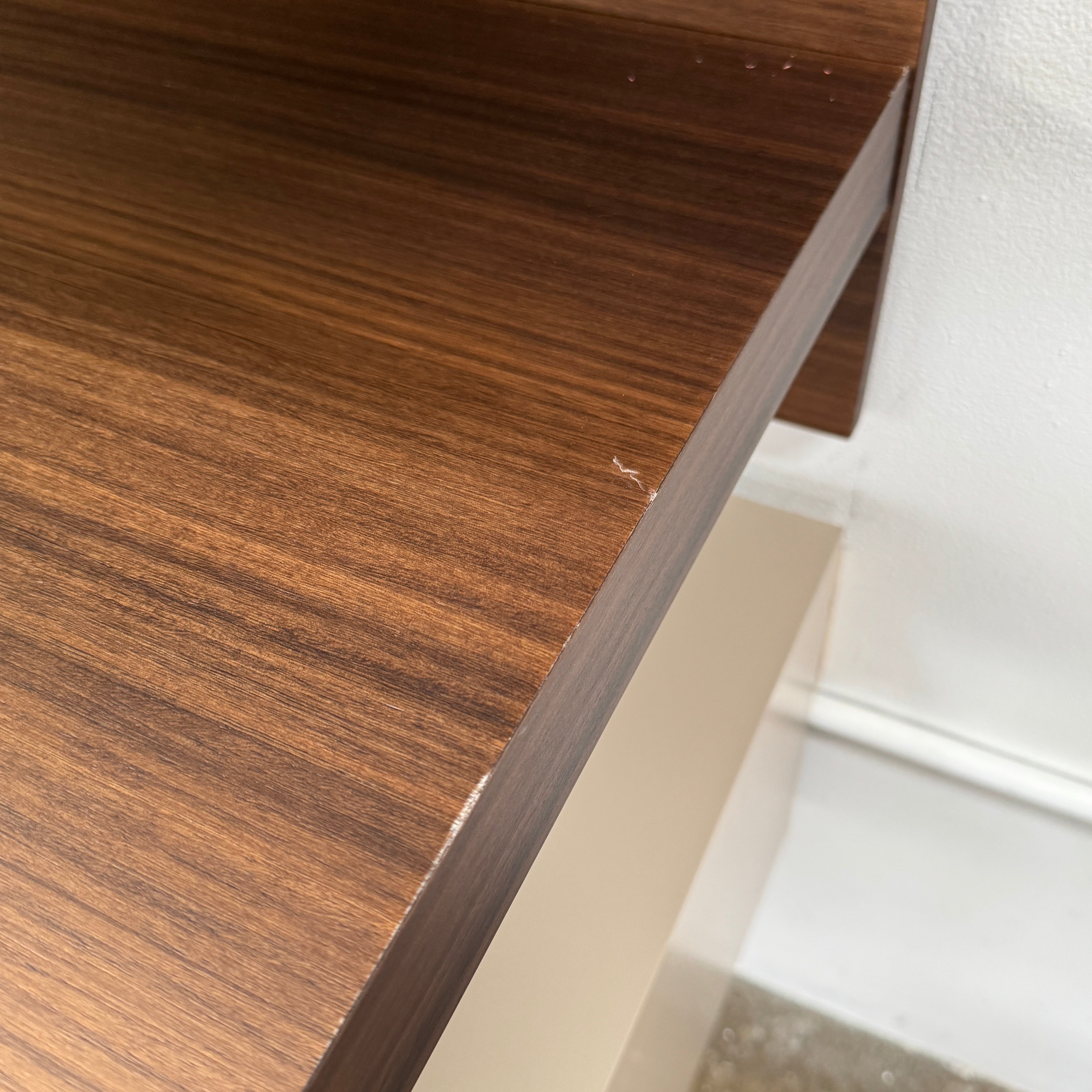 The Molteni & C Fortepiano Wall-mounted Desk System features a long wooden shelf, beige storage cabinets, and drawers for a sleek, modern look against a white wall.