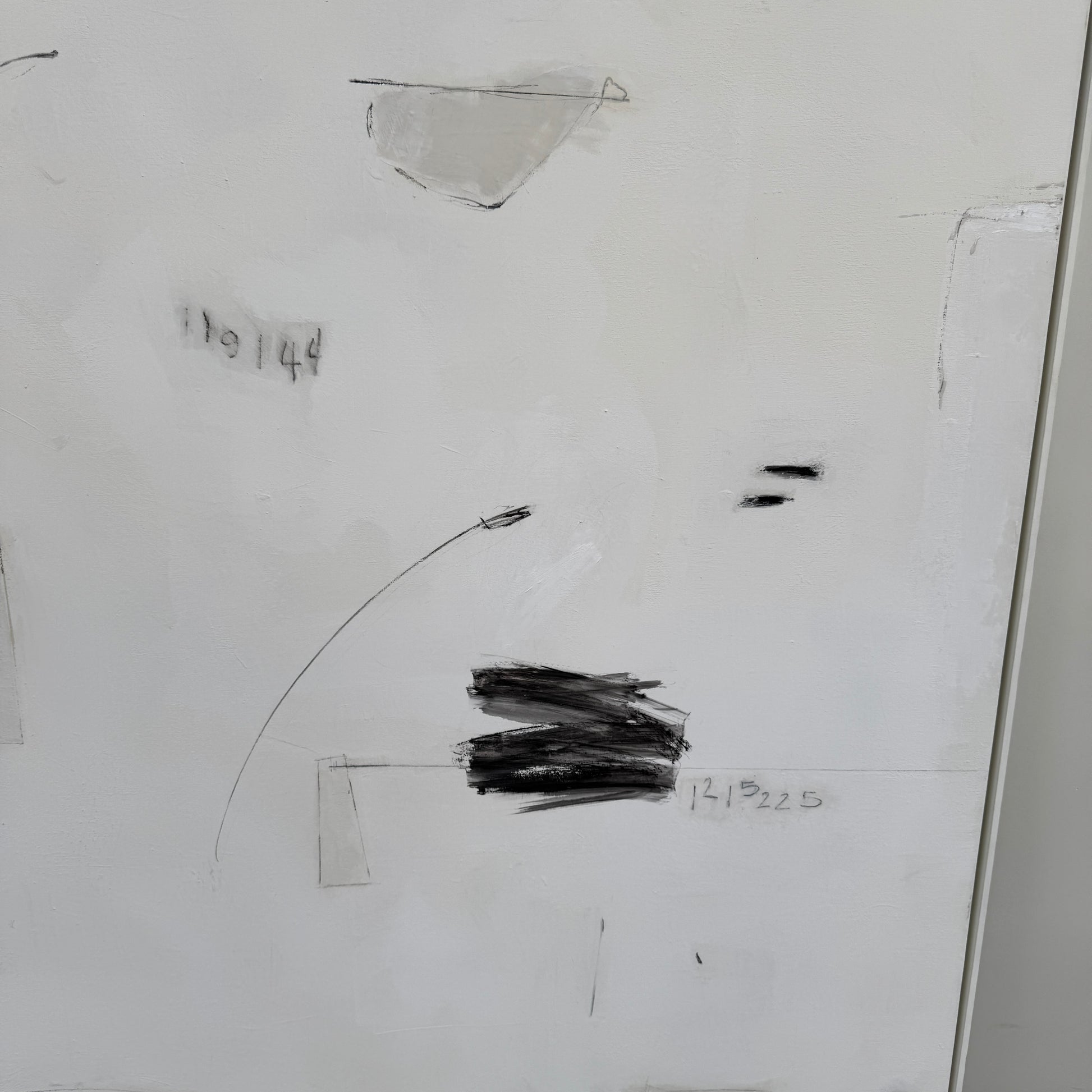 Painting: Abstract by Kimberly Moore from Artist features bold black brush strokes, faint geometric shapes, and subtle lines in black and white, leaning against a white wall on a concrete floor.