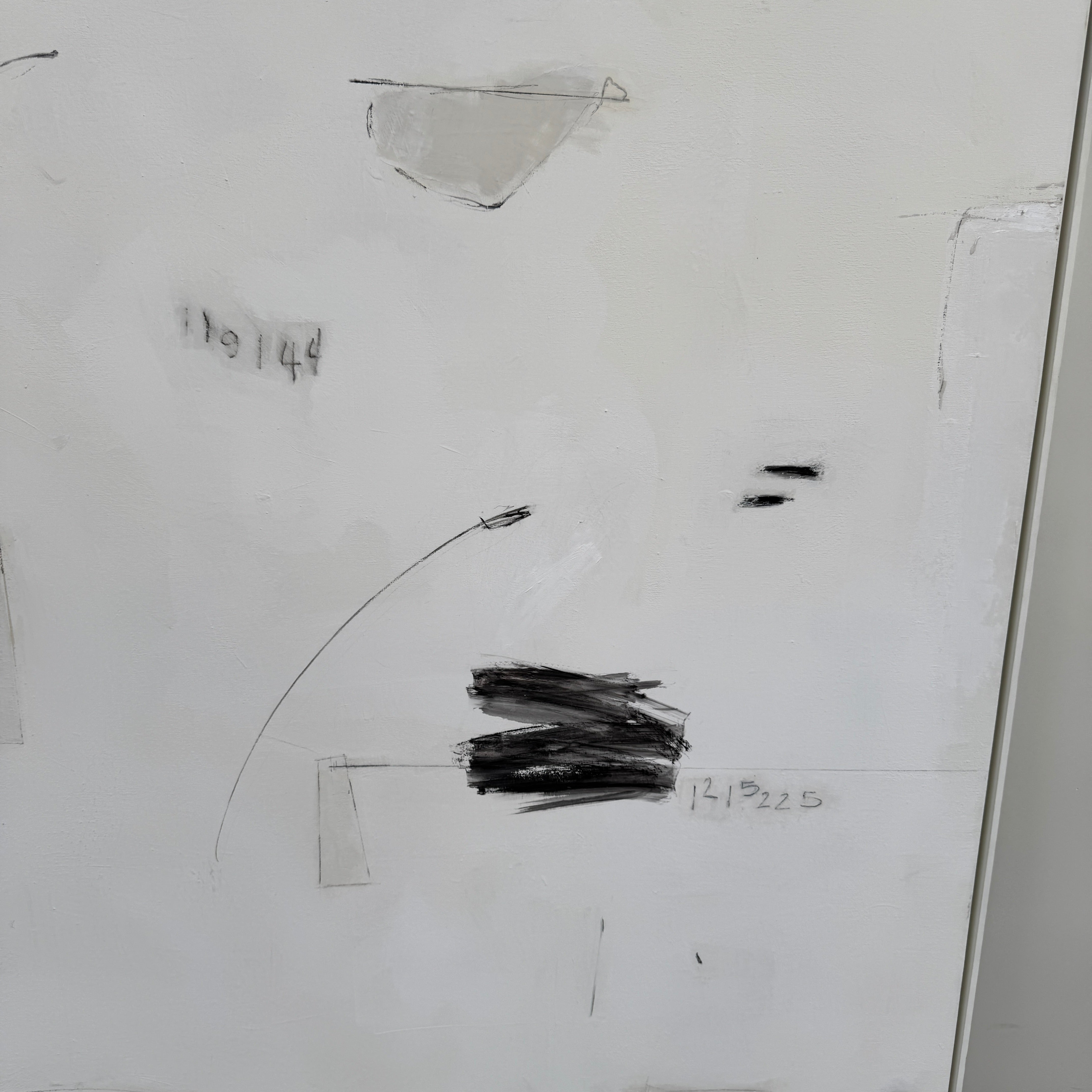 Painting: Abstract by Kimberly Moore from Artist features bold black brush strokes, faint geometric shapes, and subtle lines in black and white, leaning against a white wall on a concrete floor.