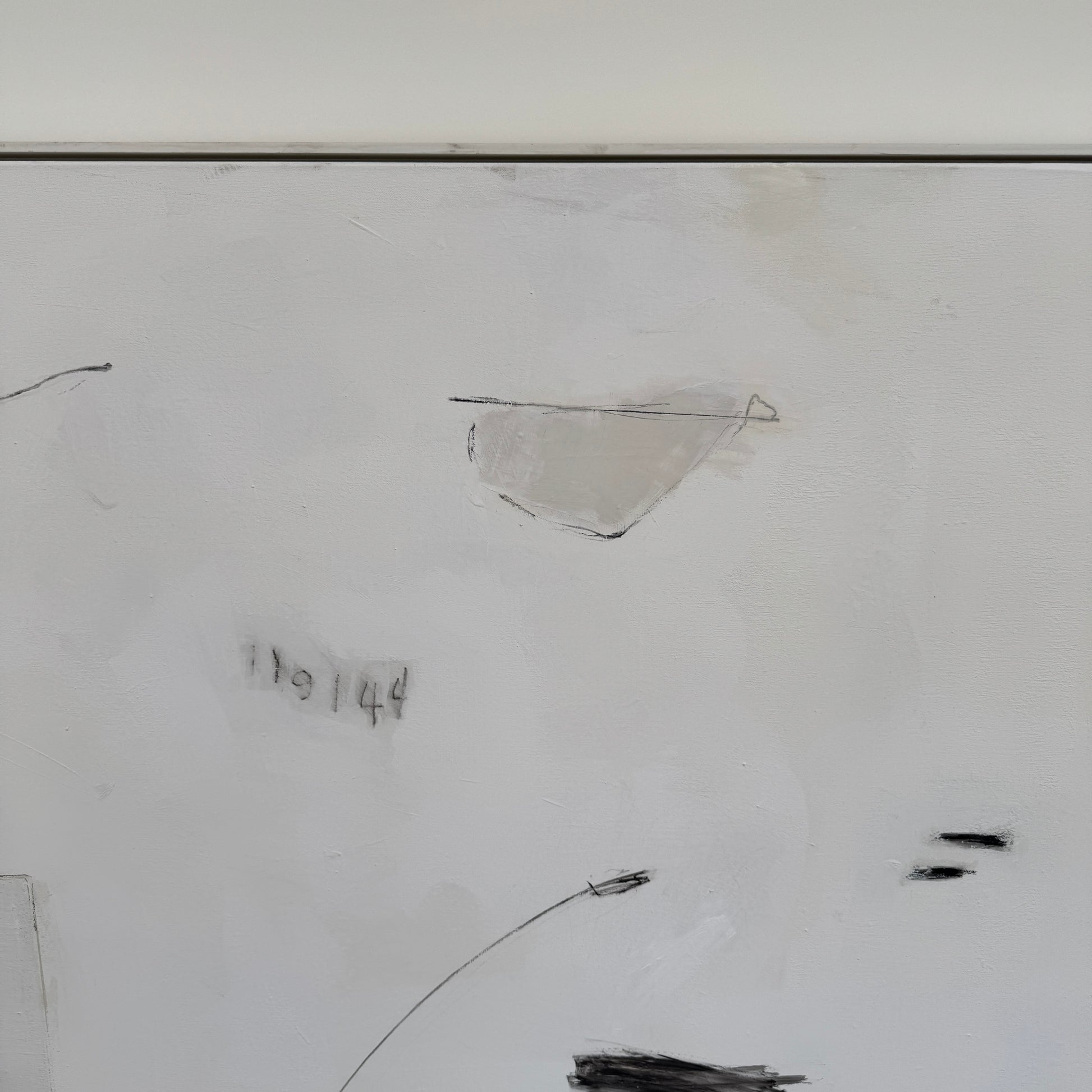 Painting: Abstract by Kimberly Moore from Artist features bold black brush strokes, faint geometric shapes, and subtle lines in black and white, leaning against a white wall on a concrete floor.