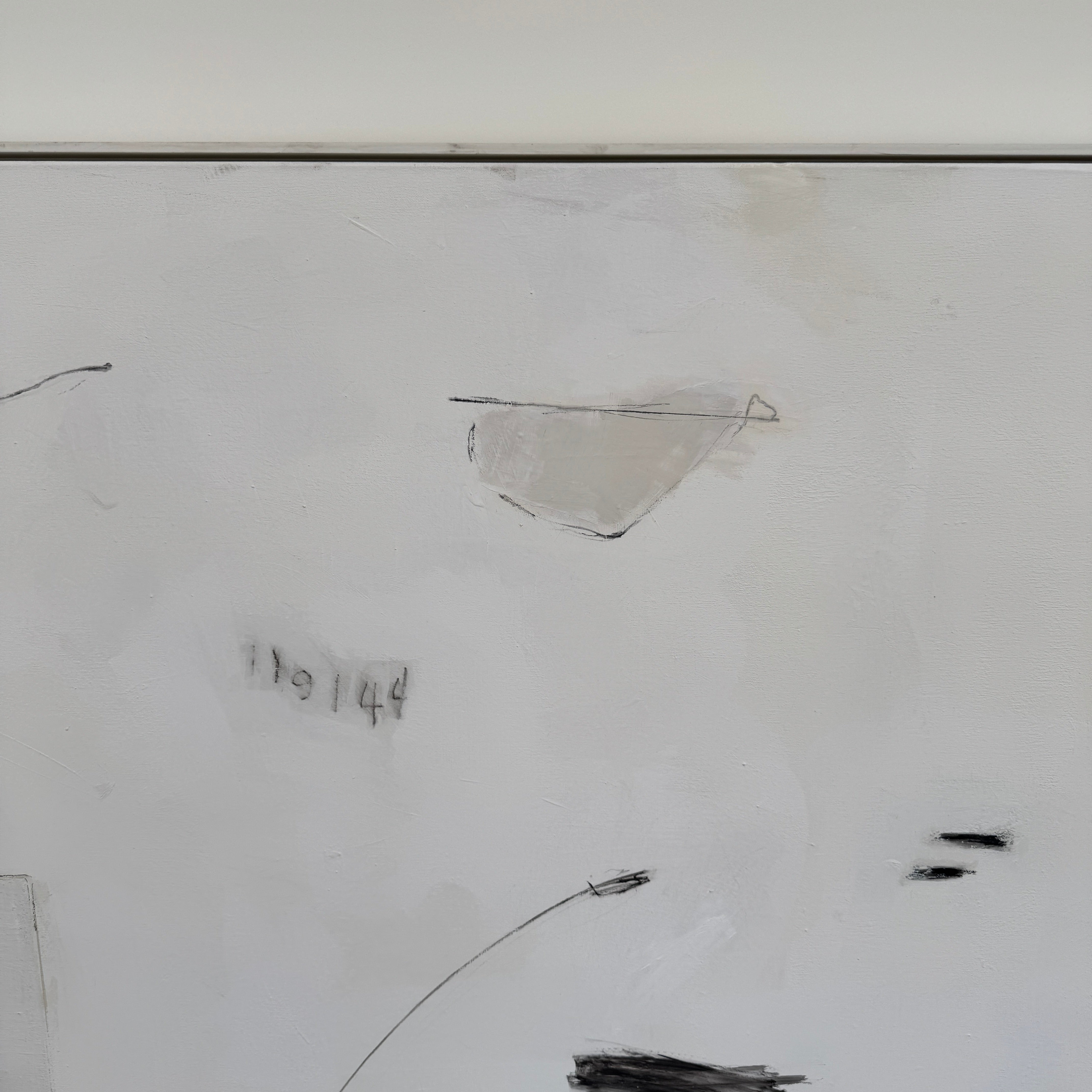 Painting: Abstract by Kimberly Moore from Artist features bold black brush strokes, faint geometric shapes, and subtle lines in black and white, leaning against a white wall on a concrete floor.