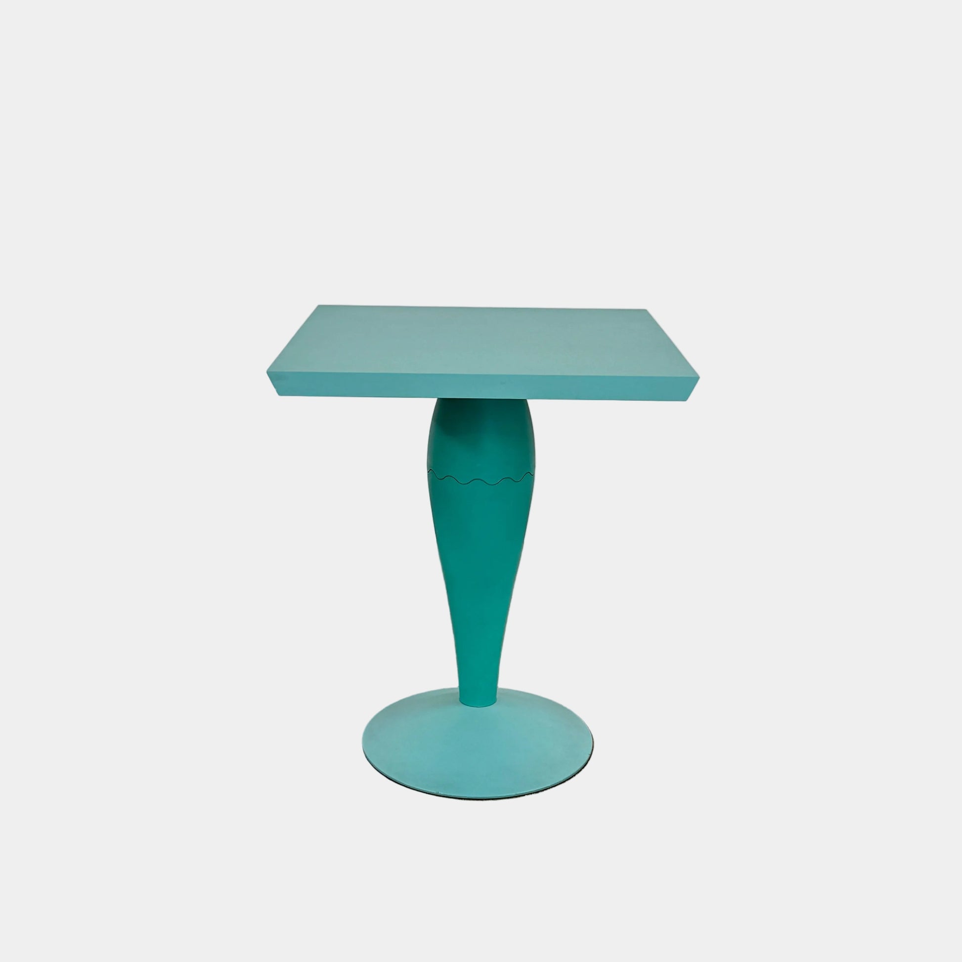 The Vintage Kartell Miss Balu Table by Kartell is a small, square turquoise plastic table with a central pedestal and round base, shown on a plain white background.