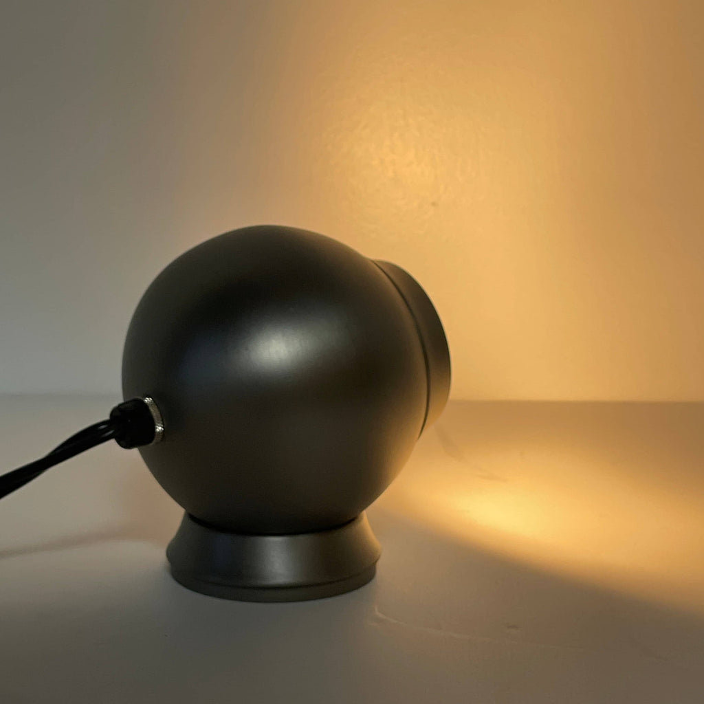 A gray Pip-Squeak Table Light on top of a white background.