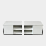 Two identical B&B Italia Surface Nightstands by B&B Italia, in a chic white finish with black trim, each featuring two drawers and open shelving in the middle. These modern pieces are perfect for any contemporary bedroom furniture arrangement.