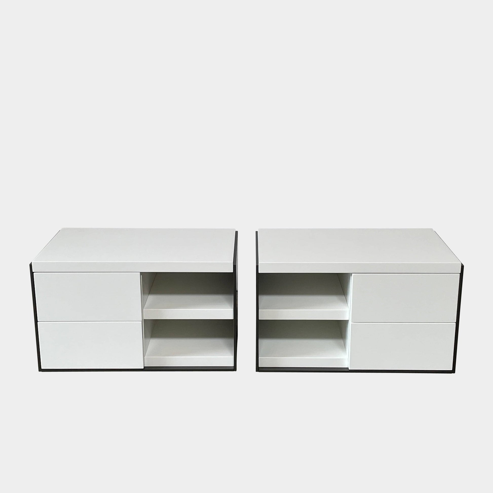 Two identical B&B Italia Surface Nightstands by B&B Italia, in a chic white finish with black trim, each featuring two drawers and open shelving in the middle. These modern pieces are perfect for any contemporary bedroom furniture arrangement.