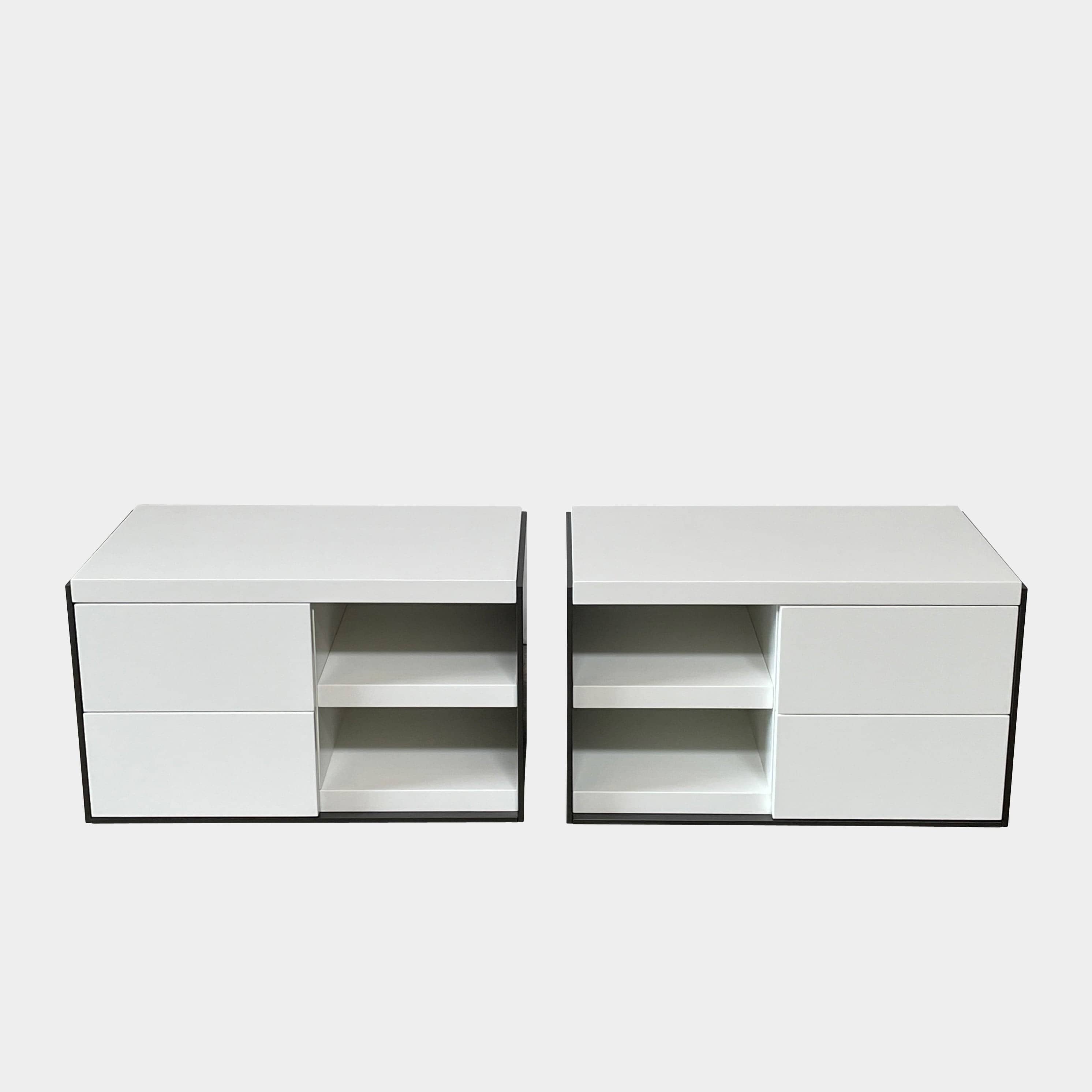 Two identical B&B Italia Surface Nightstands by B&B Italia, in a chic white finish with black trim, each featuring two drawers and open shelving in the middle. These modern pieces are perfect for any contemporary bedroom furniture arrangement.