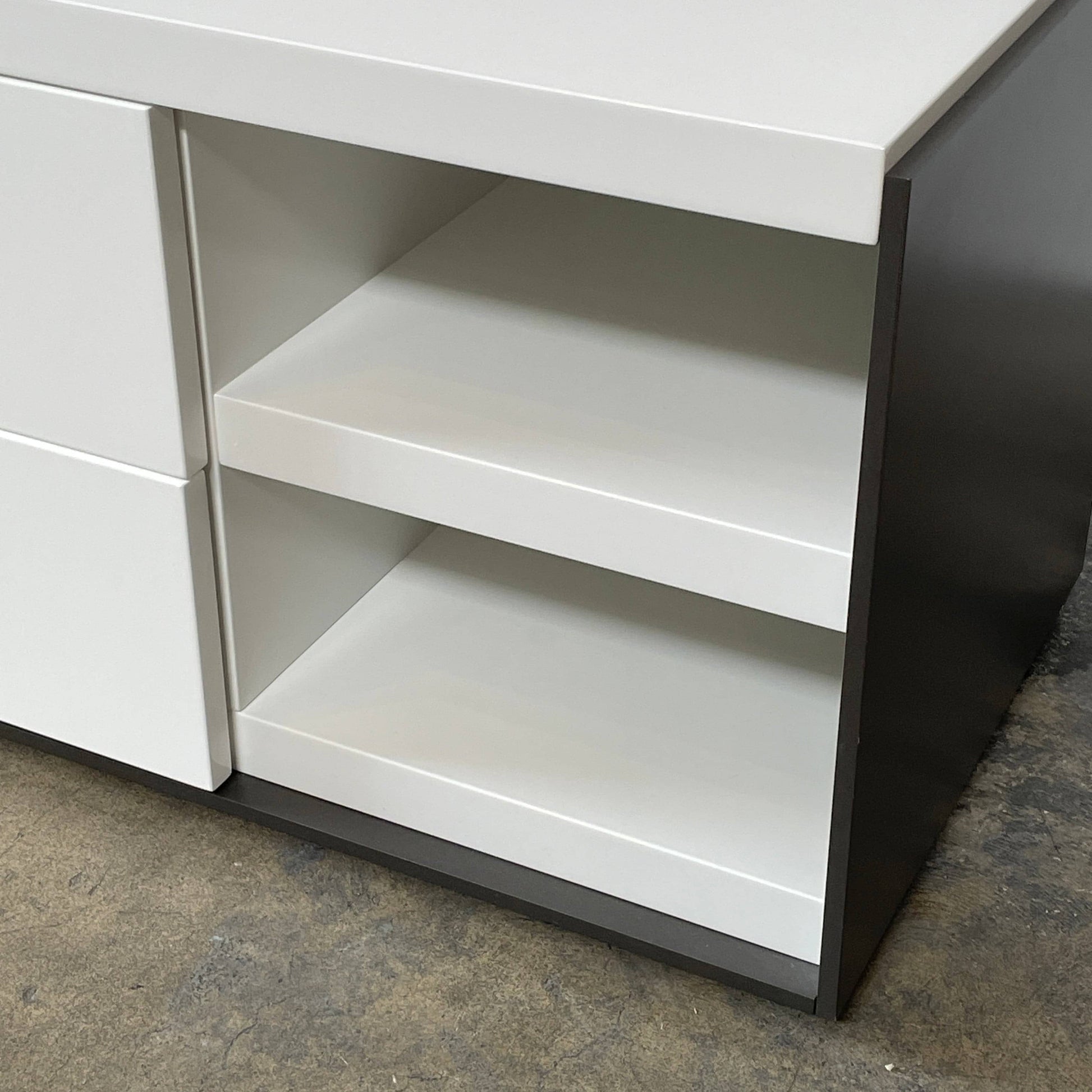 Two identical B&B Italia Surface Nightstands by B&B Italia, in a chic white finish with black trim, each featuring two drawers and open shelving in the middle. These modern pieces are perfect for any contemporary bedroom furniture arrangement.