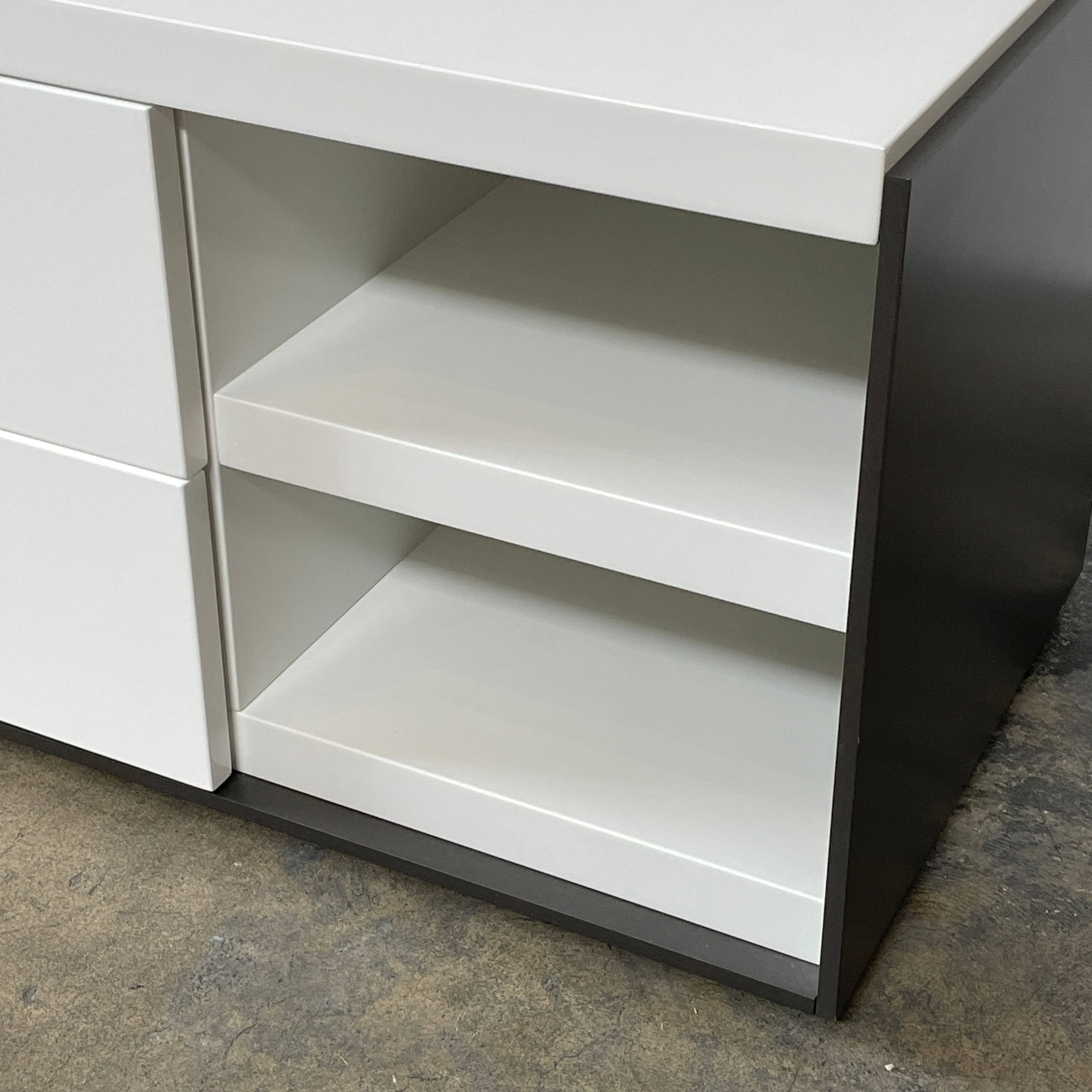 Two identical B&B Italia Surface Nightstands by B&B Italia, in a chic white finish with black trim, each featuring two drawers and open shelving in the middle. These modern pieces are perfect for any contemporary bedroom furniture arrangement.