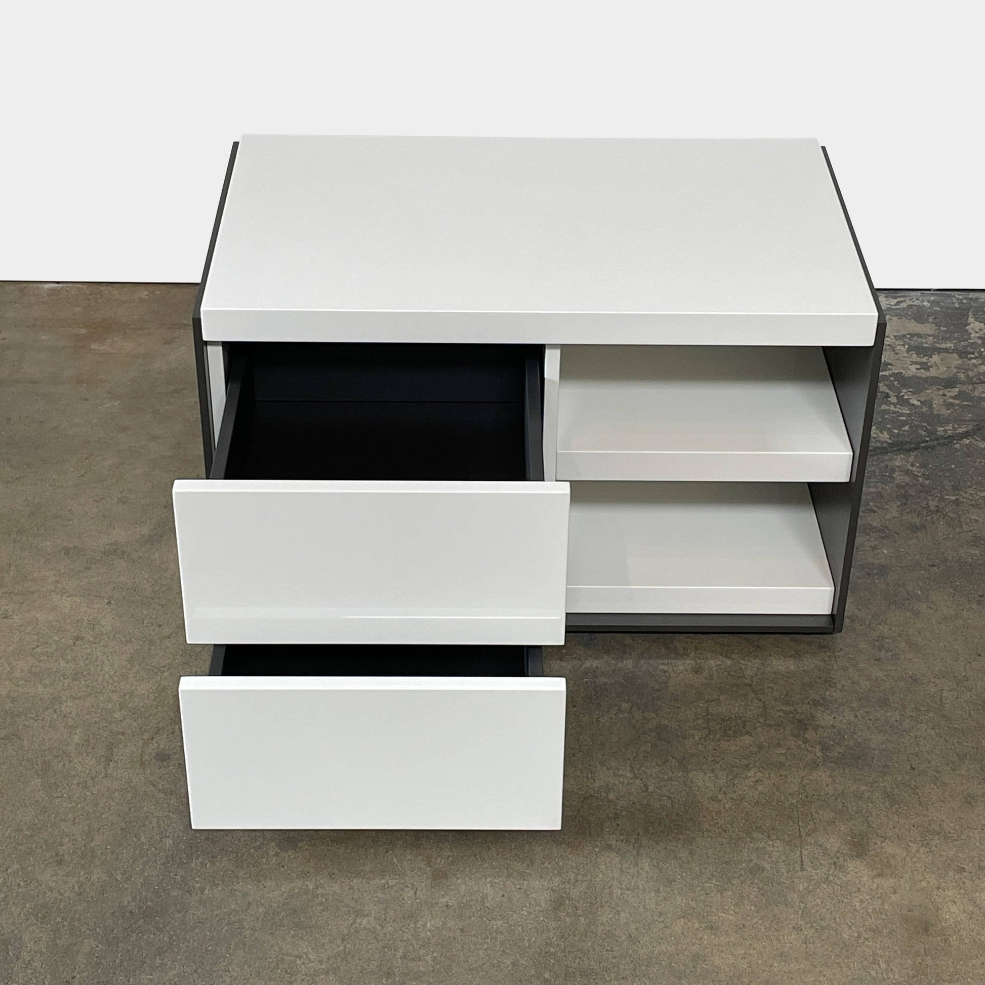 Two identical B&B Italia Surface Nightstands by B&B Italia, in a chic white finish with black trim, each featuring two drawers and open shelving in the middle. These modern pieces are perfect for any contemporary bedroom furniture arrangement.