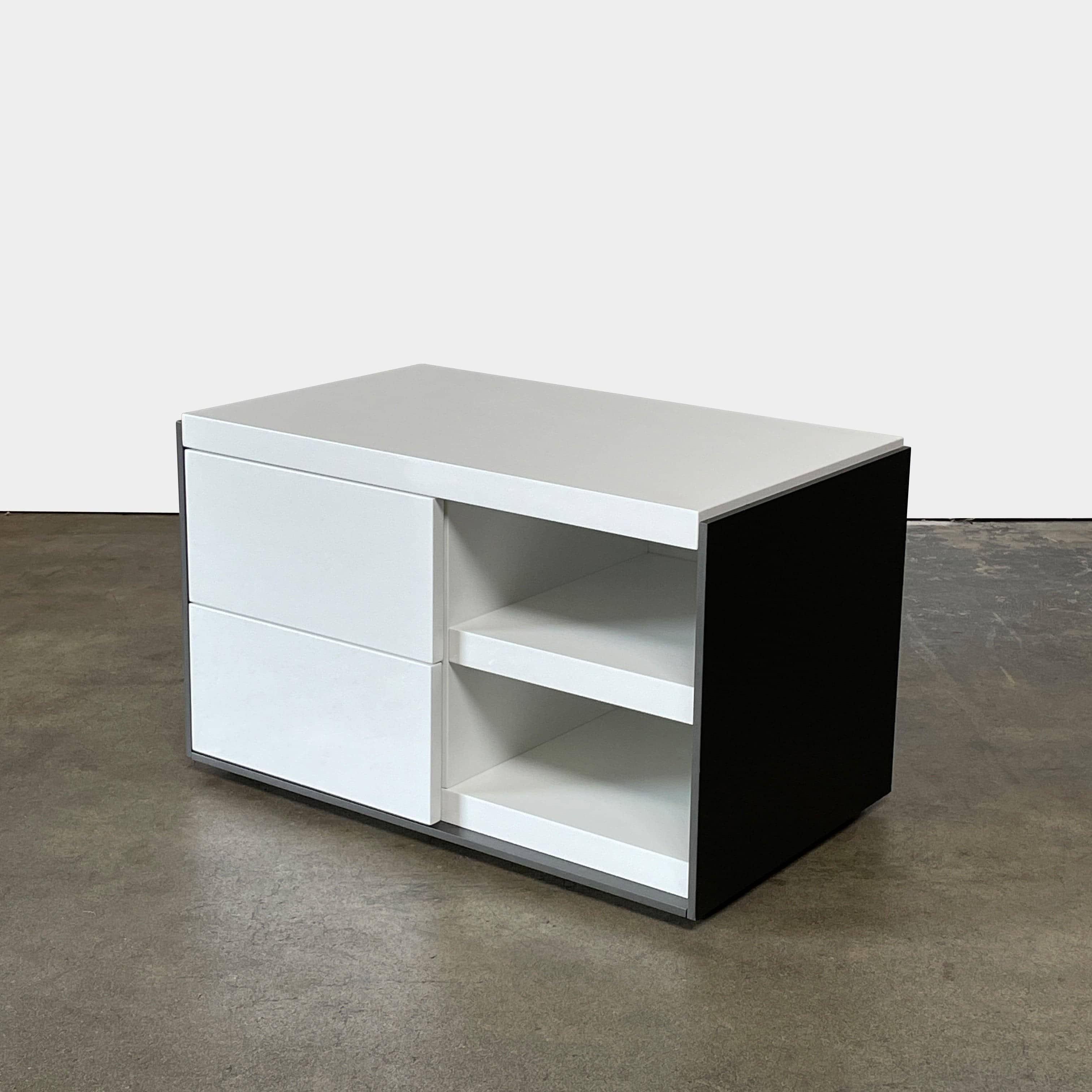 Two identical B&B Italia Surface Nightstands by B&B Italia, in a chic white finish with black trim, each featuring two drawers and open shelving in the middle. These modern pieces are perfect for any contemporary bedroom furniture arrangement.