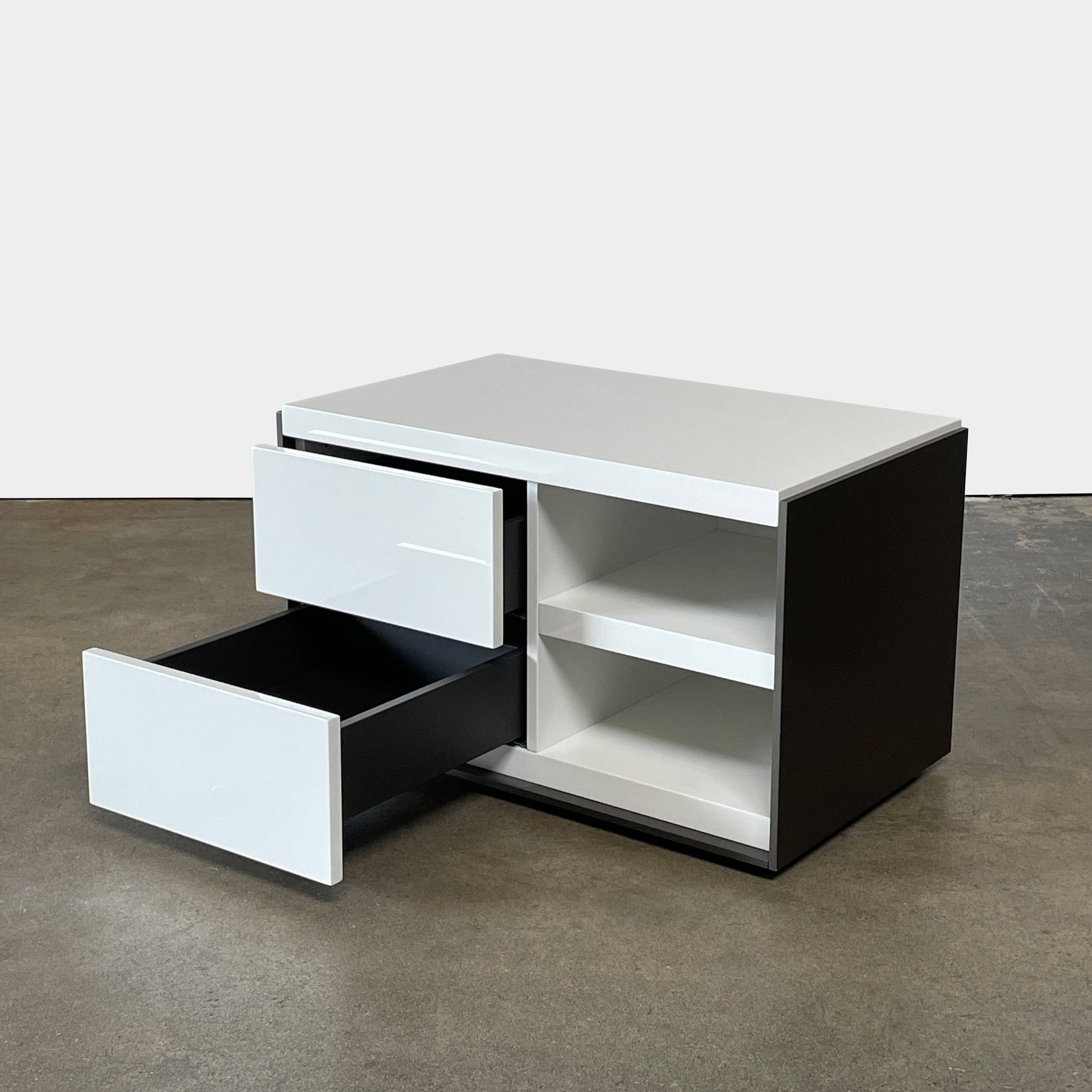 Two identical B&B Italia Surface Nightstands by B&B Italia, in a chic white finish with black trim, each featuring two drawers and open shelving in the middle. These modern pieces are perfect for any contemporary bedroom furniture arrangement.