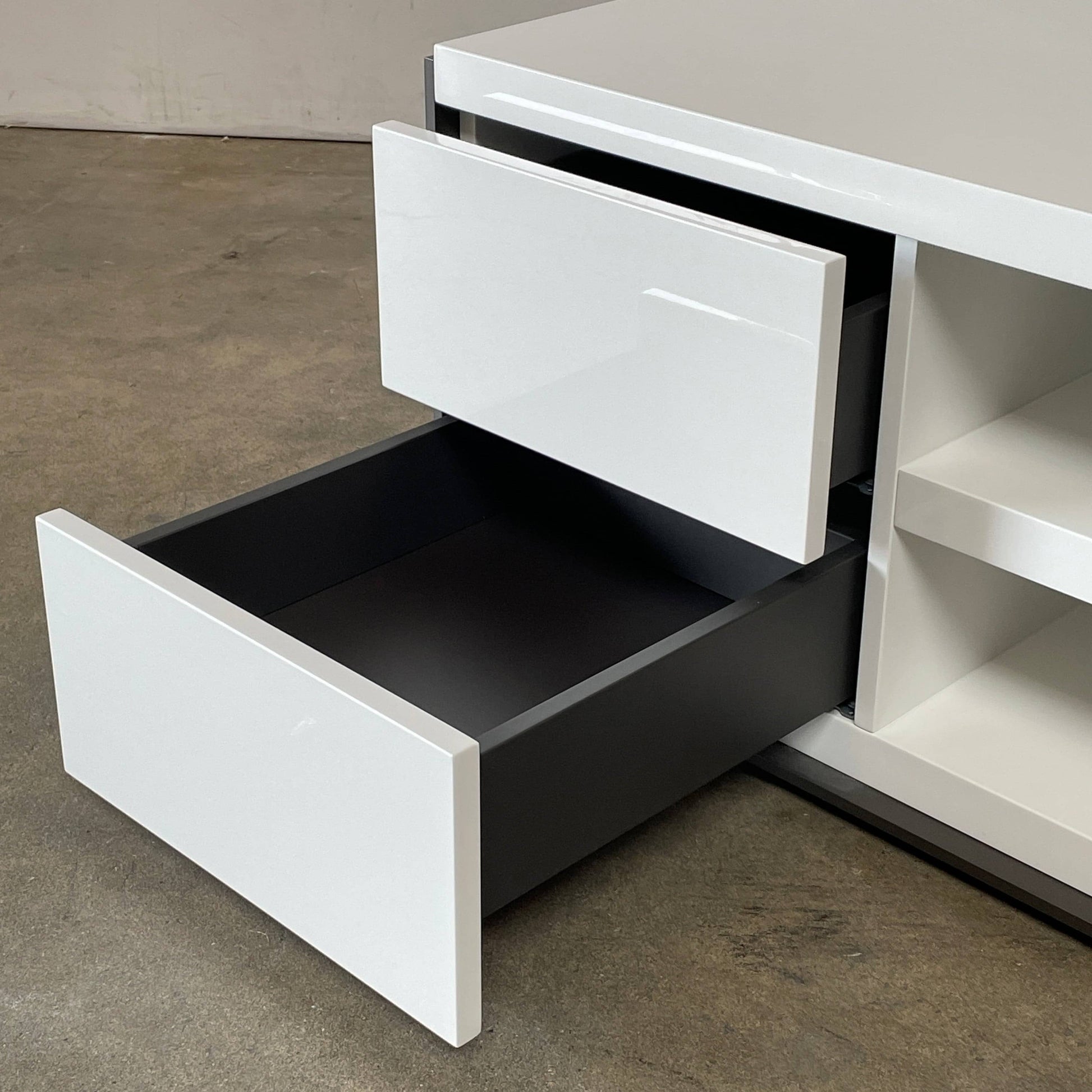 Two identical B&B Italia Surface Nightstands by B&B Italia, in a chic white finish with black trim, each featuring two drawers and open shelving in the middle. These modern pieces are perfect for any contemporary bedroom furniture arrangement.