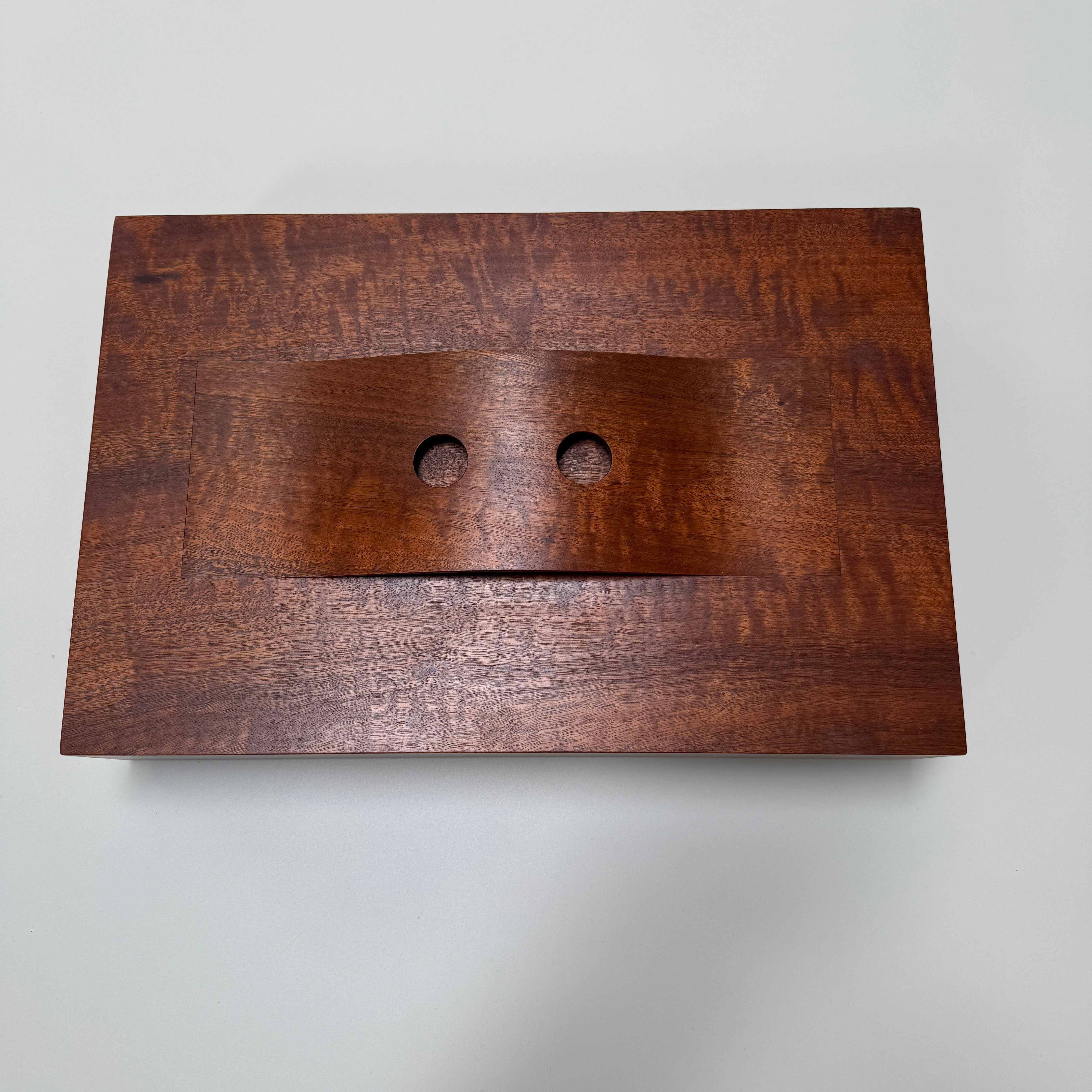 The Mike Fair Jewelry / Cigar Box by Mike Fair Custom Furnishings is a rectangular handcrafted box with a lid featuring a curved cutout and two circular holes, displayed against a plain white background.