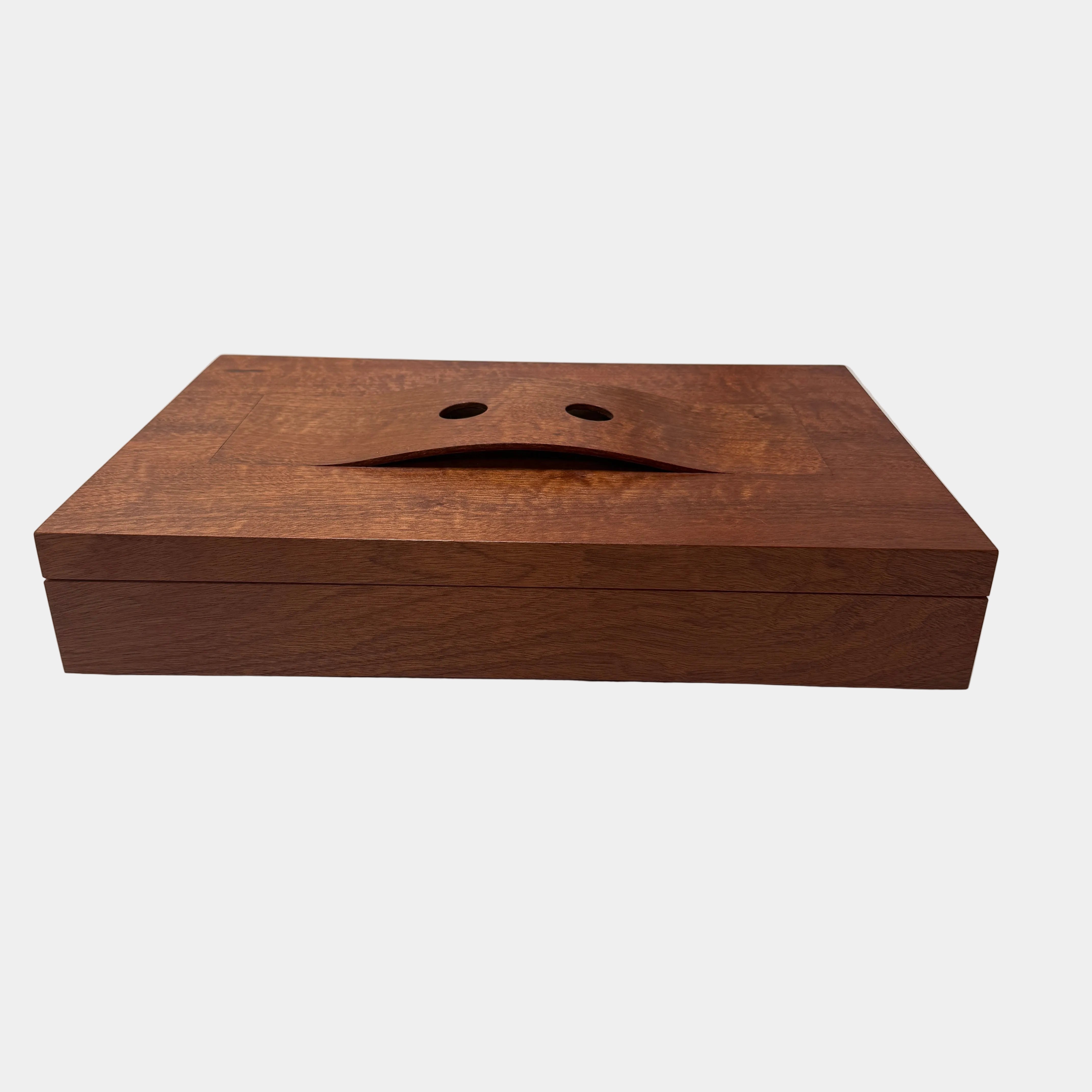 The Mike Fair Jewelry / Cigar Box by Mike Fair Custom Furnishings is a rectangular handcrafted box with a lid featuring a curved cutout and two circular holes, displayed against a plain white background.