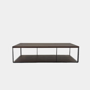 The Maxalto Lithos Coffee Table by Maxalto features a rectangular dark wood top and lower shelf, supported by a minimalist black metal frame, and is displayed against a plain white background.