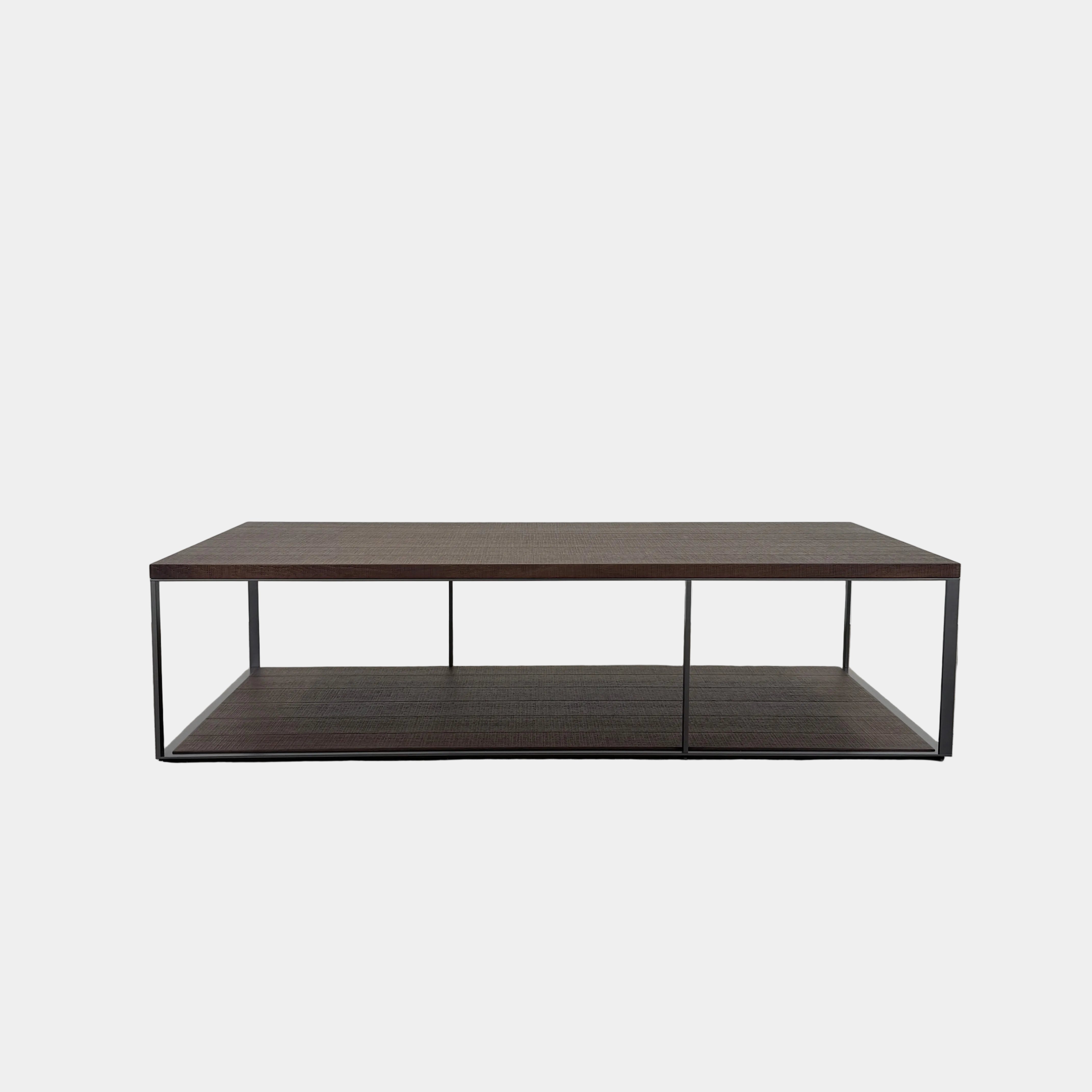 The Maxalto Lithos Coffee Table by Maxalto features a rectangular dark wood top and lower shelf, supported by a minimalist black metal frame, and is displayed against a plain white background.