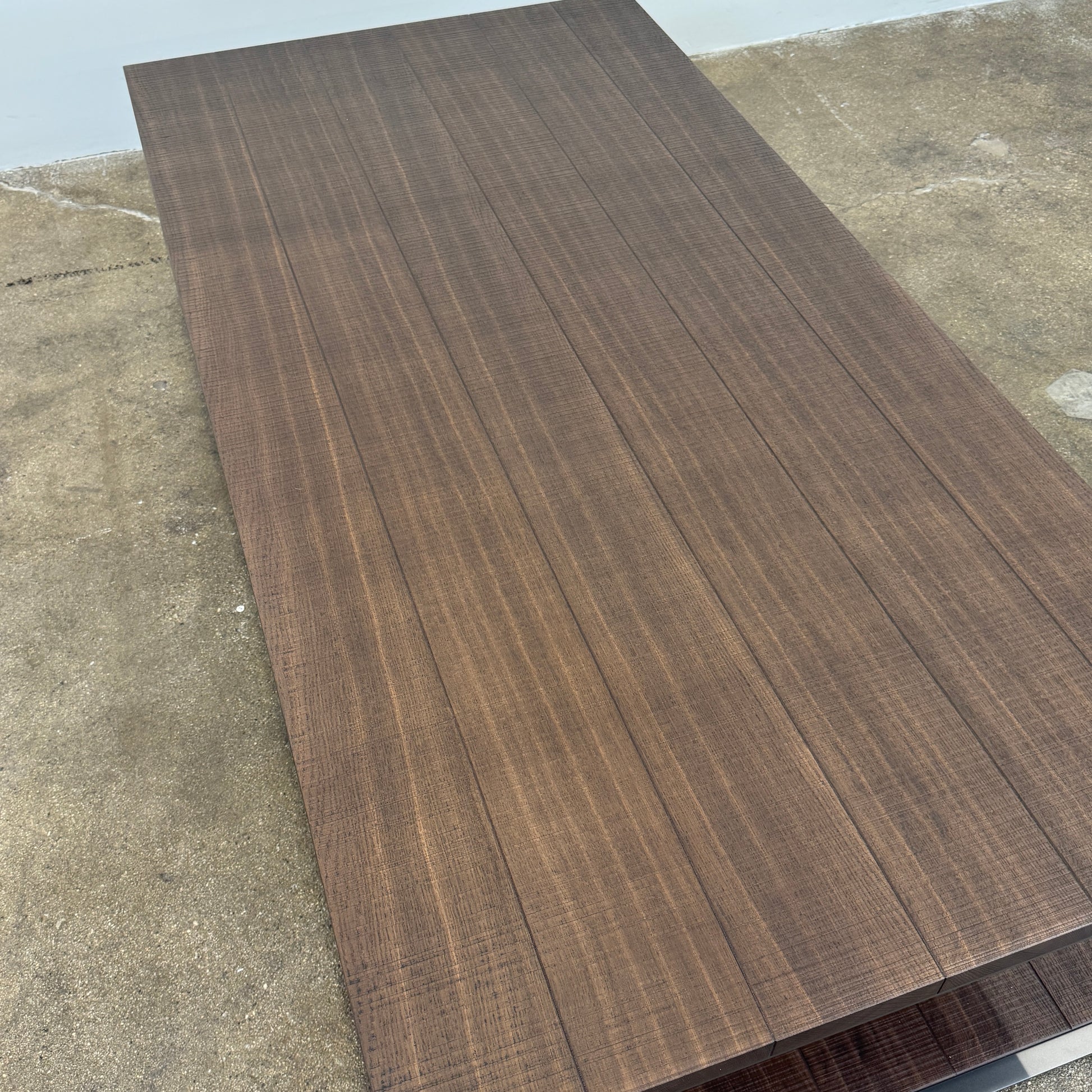 The Maxalto Lithos Coffee Table by Maxalto features a rectangular dark wood top and lower shelf, supported by a minimalist black metal frame, and is displayed against a plain white background.