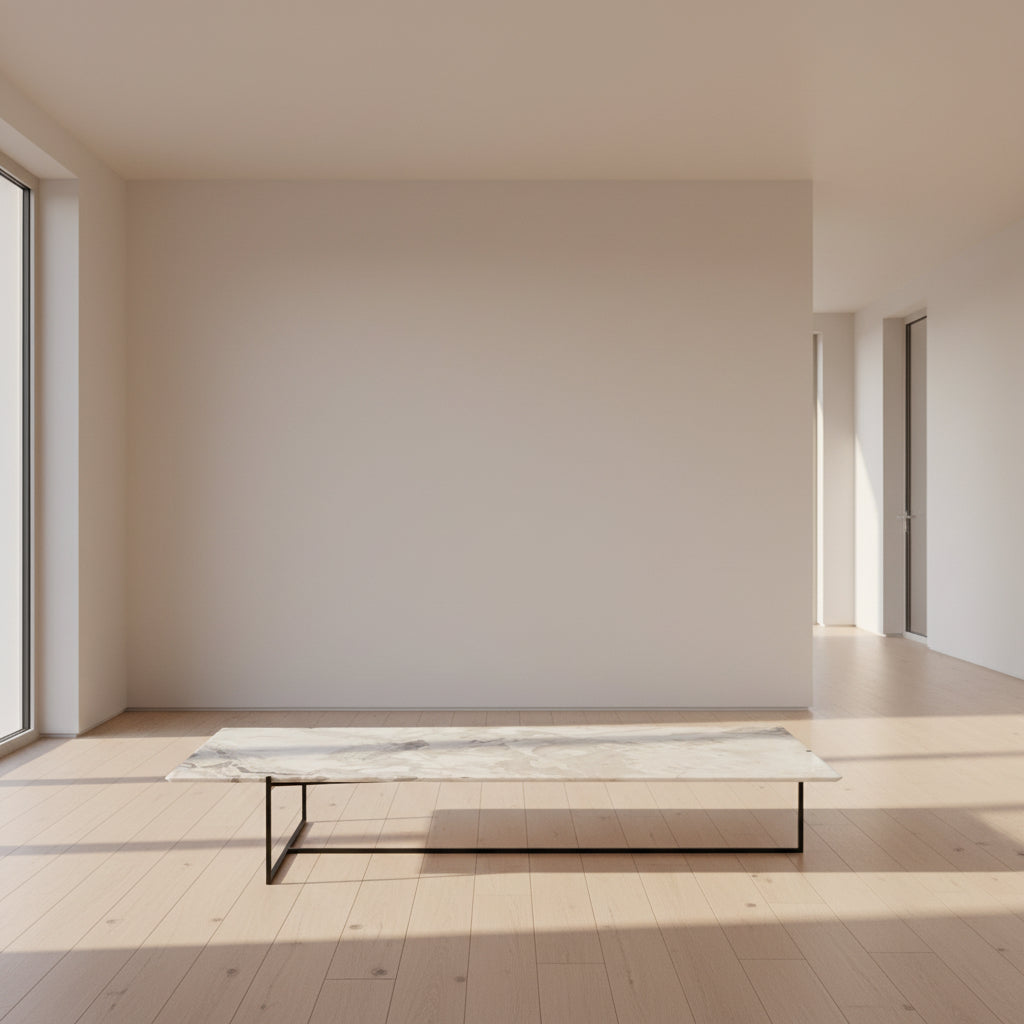 The Baxter Coffee Table Icaro Stone by Modern Resale, featuring a rectangular marble top and slim black metal frame, is set on a polished concrete floor against a plain light-colored wall.