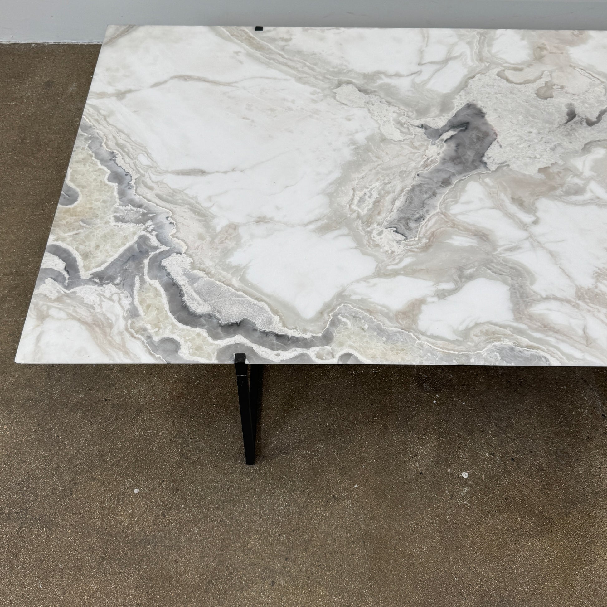 The Baxter Icaro Rectangular Coffee Table by Baxter features a Polar White Marble top with off-white, gray, and beige veining on a slim black metal frame, shown against a white background for a modern look.