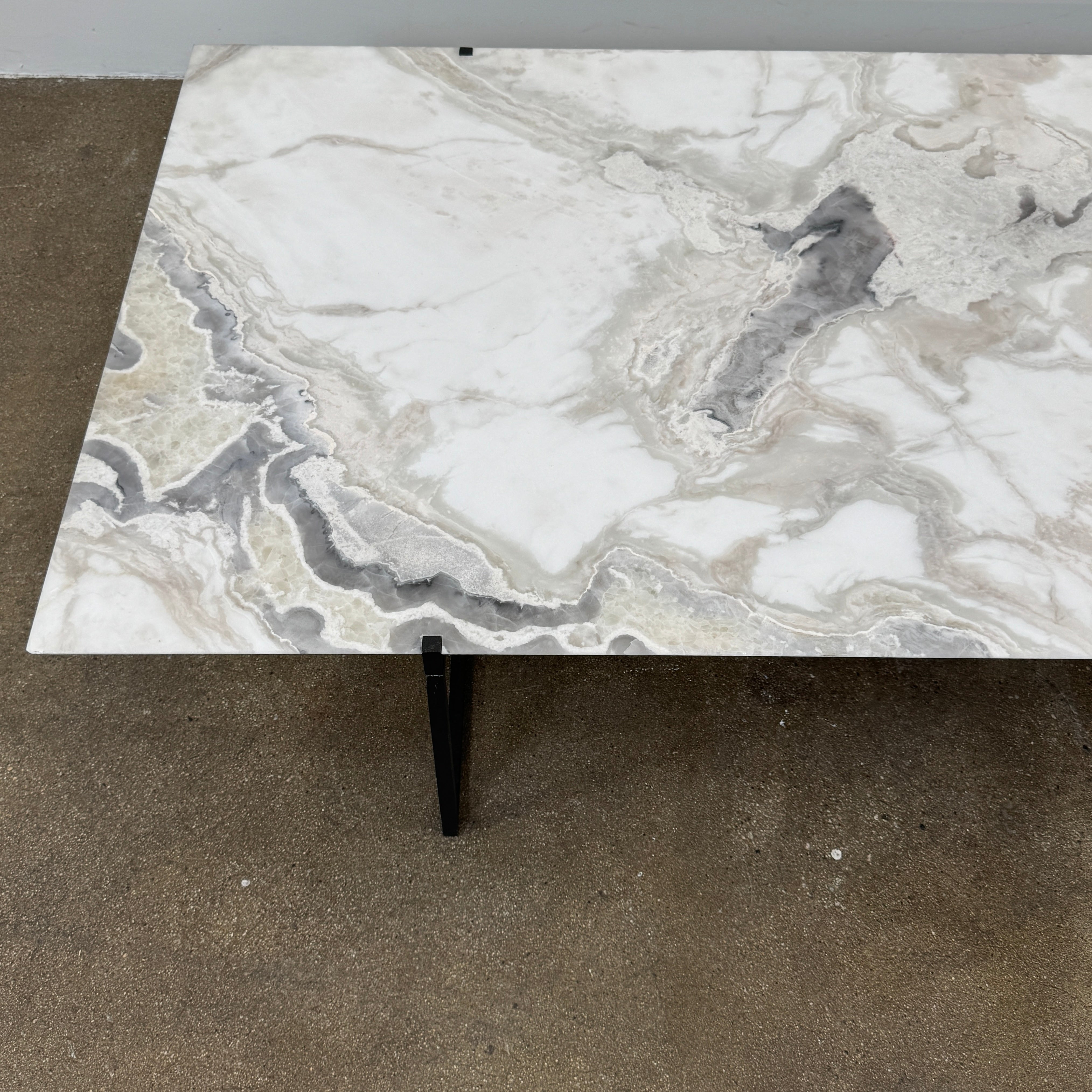 The Baxter Icaro Rectangular Coffee Table by Baxter features a Polar White Marble top with off-white, gray, and beige veining on a slim black metal frame, shown against a white background for a modern look.