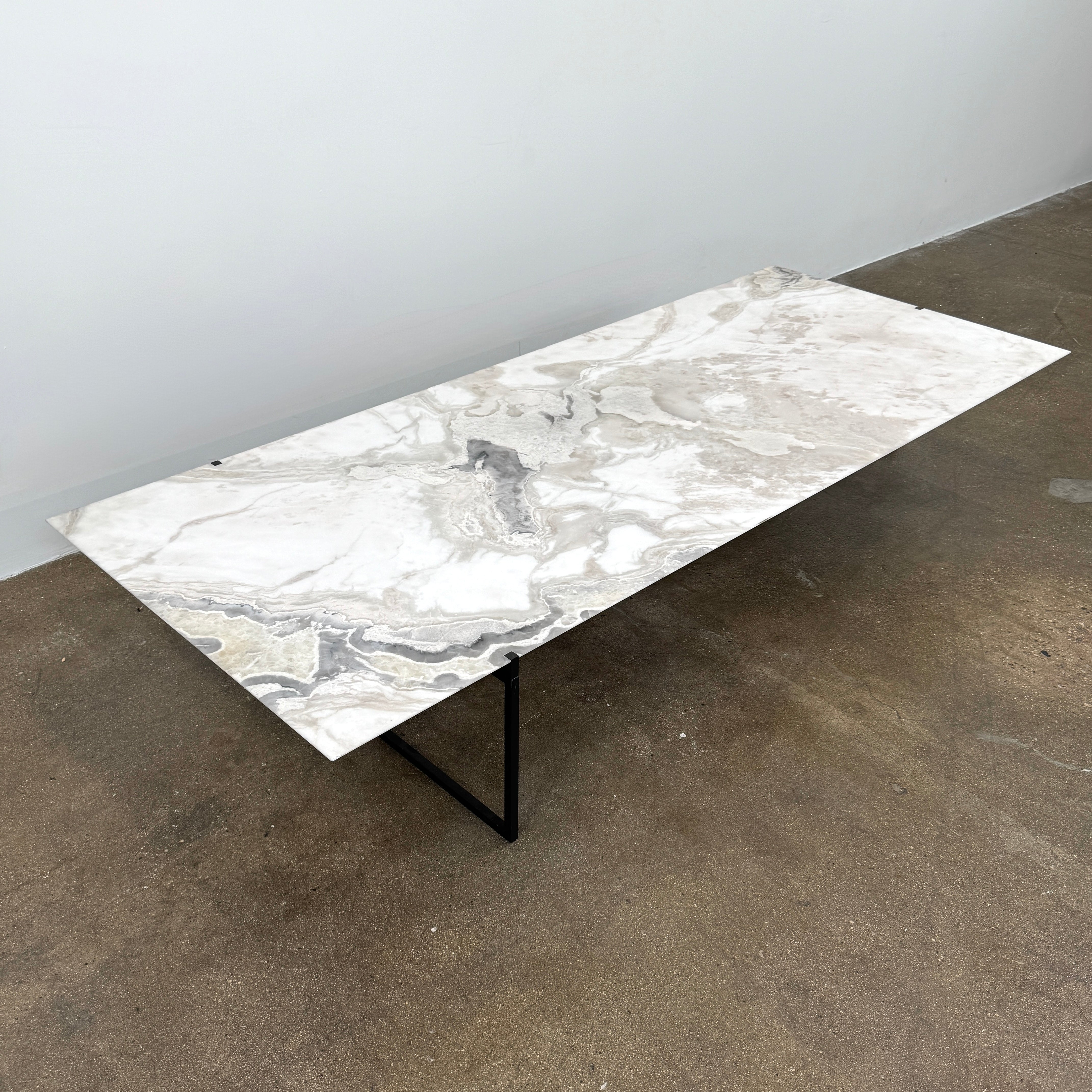 The Baxter Icaro Rectangular Coffee Table by Baxter features a Polar White Marble top with off-white, gray, and beige veining on a slim black metal frame, shown against a white background for a modern look.