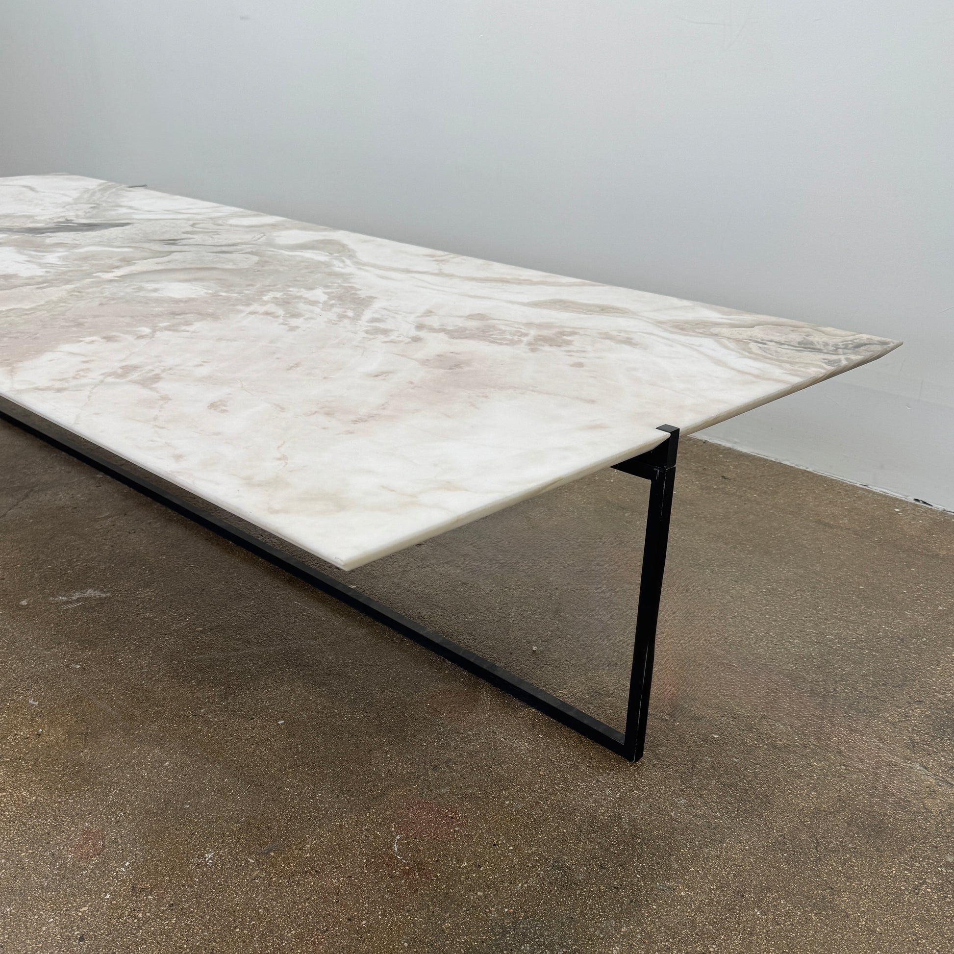 The Baxter Icaro Rectangular Coffee Table by Baxter features a Polar White Marble top with off-white, gray, and beige veining on a slim black metal frame, shown against a white background for a modern look.