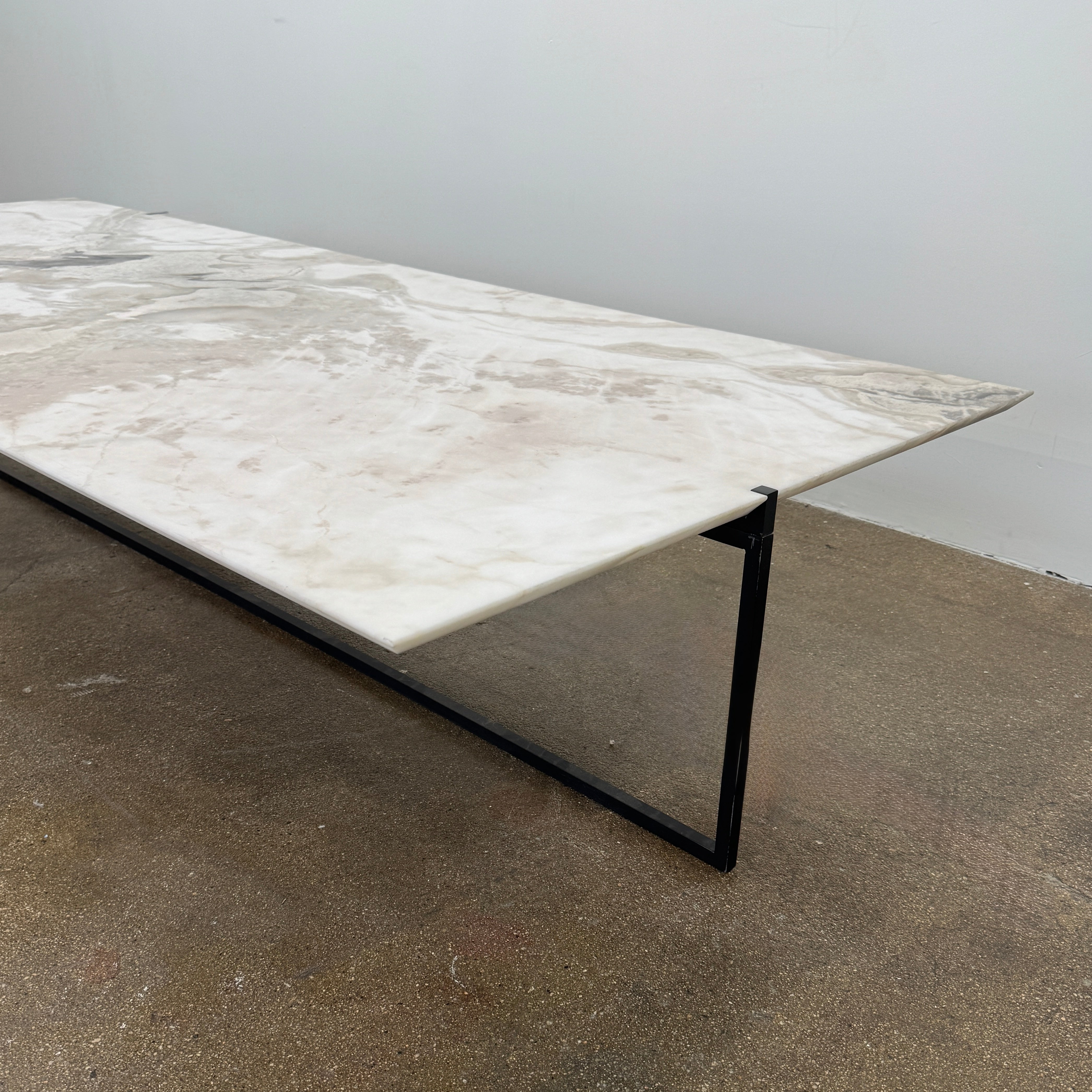 The Baxter Icaro Rectangular Coffee Table by Baxter features a Polar White Marble top with off-white, gray, and beige veining on a slim black metal frame, shown against a white background for a modern look.
