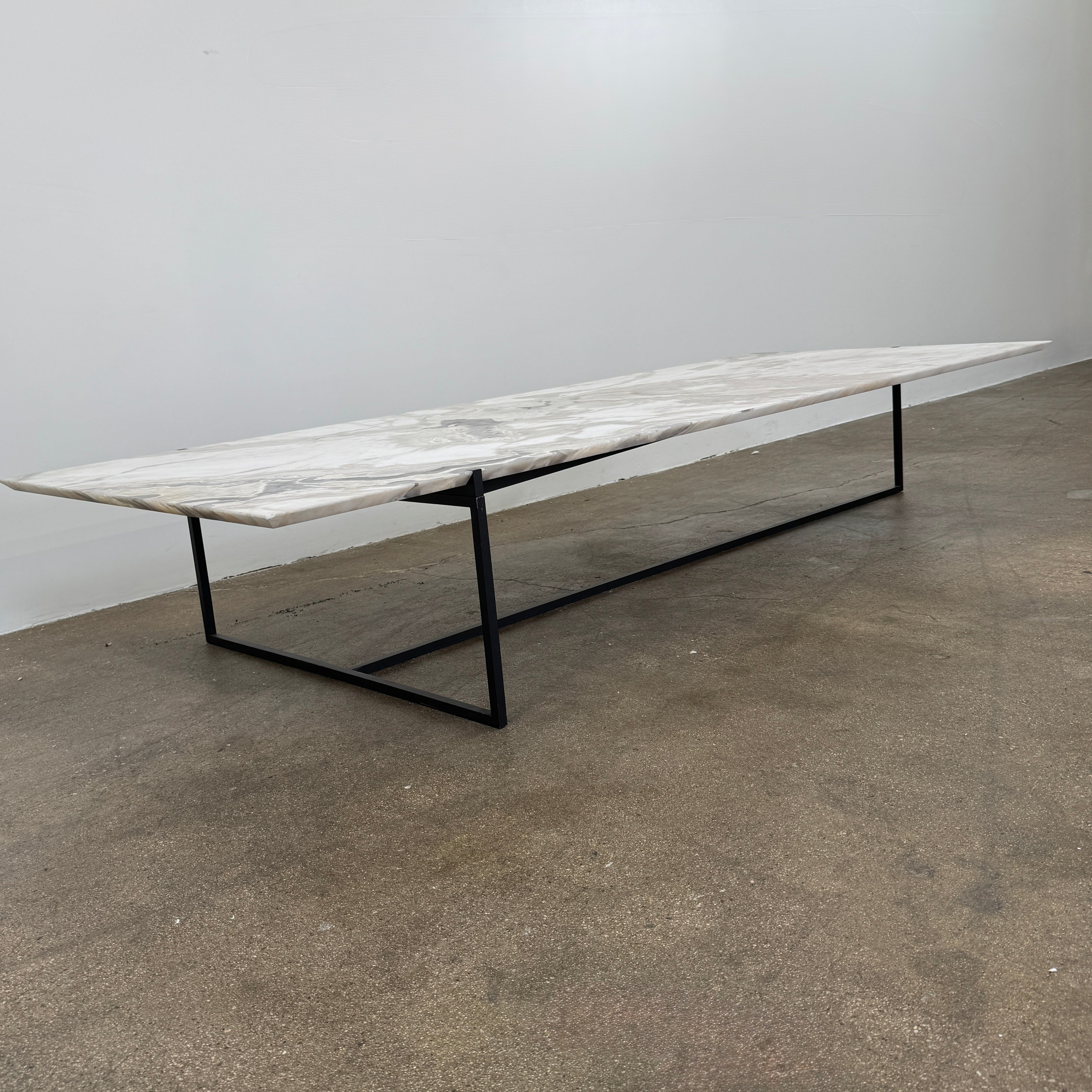 The Baxter Icaro Rectangular Coffee Table by Baxter features a Polar White Marble top with off-white, gray, and beige veining on a slim black metal frame, shown against a white background for a modern look.