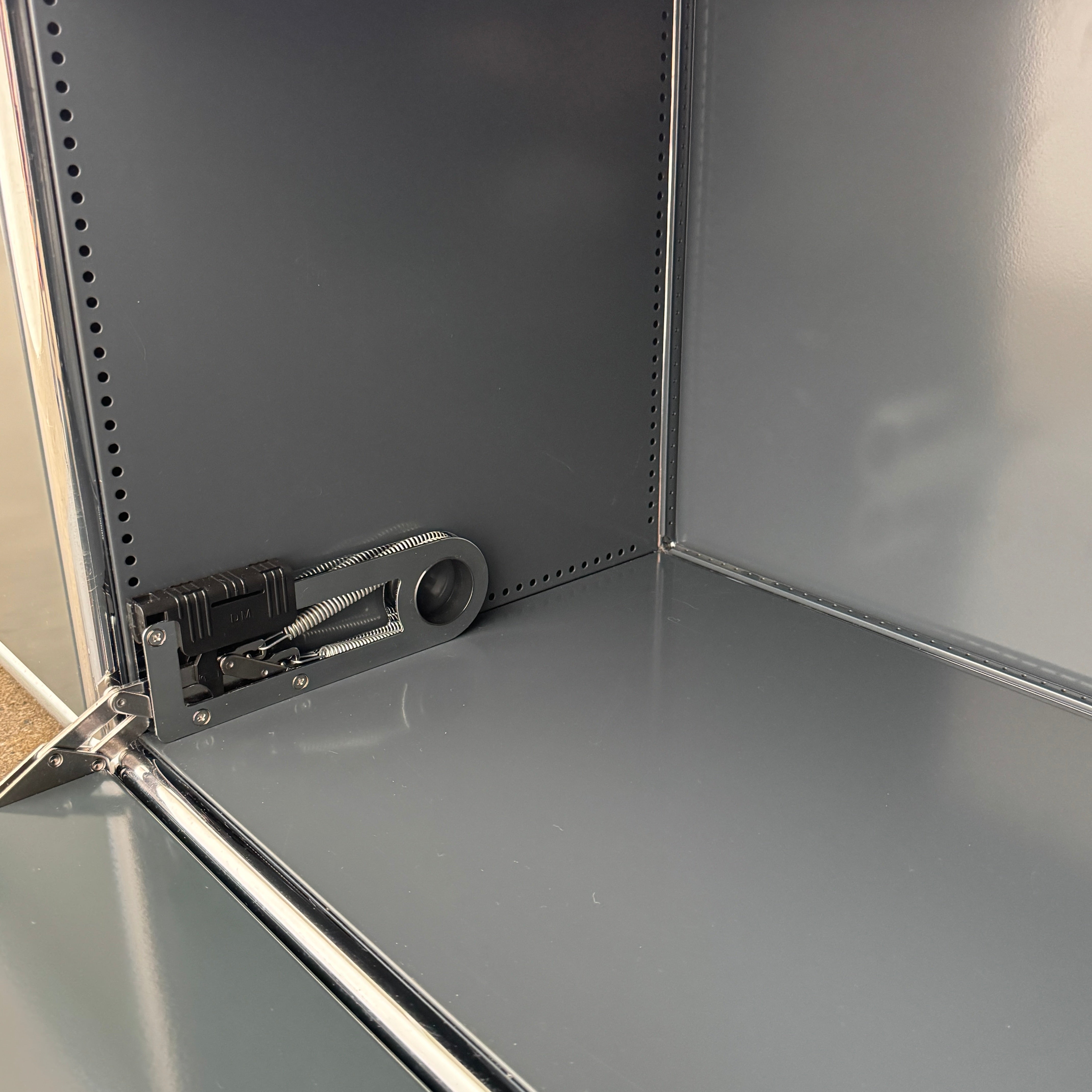 The USM Haller Low Console - Three Flap Door Unit features three black flap doors with round knobs and a silver frame, shown against a plain white background.