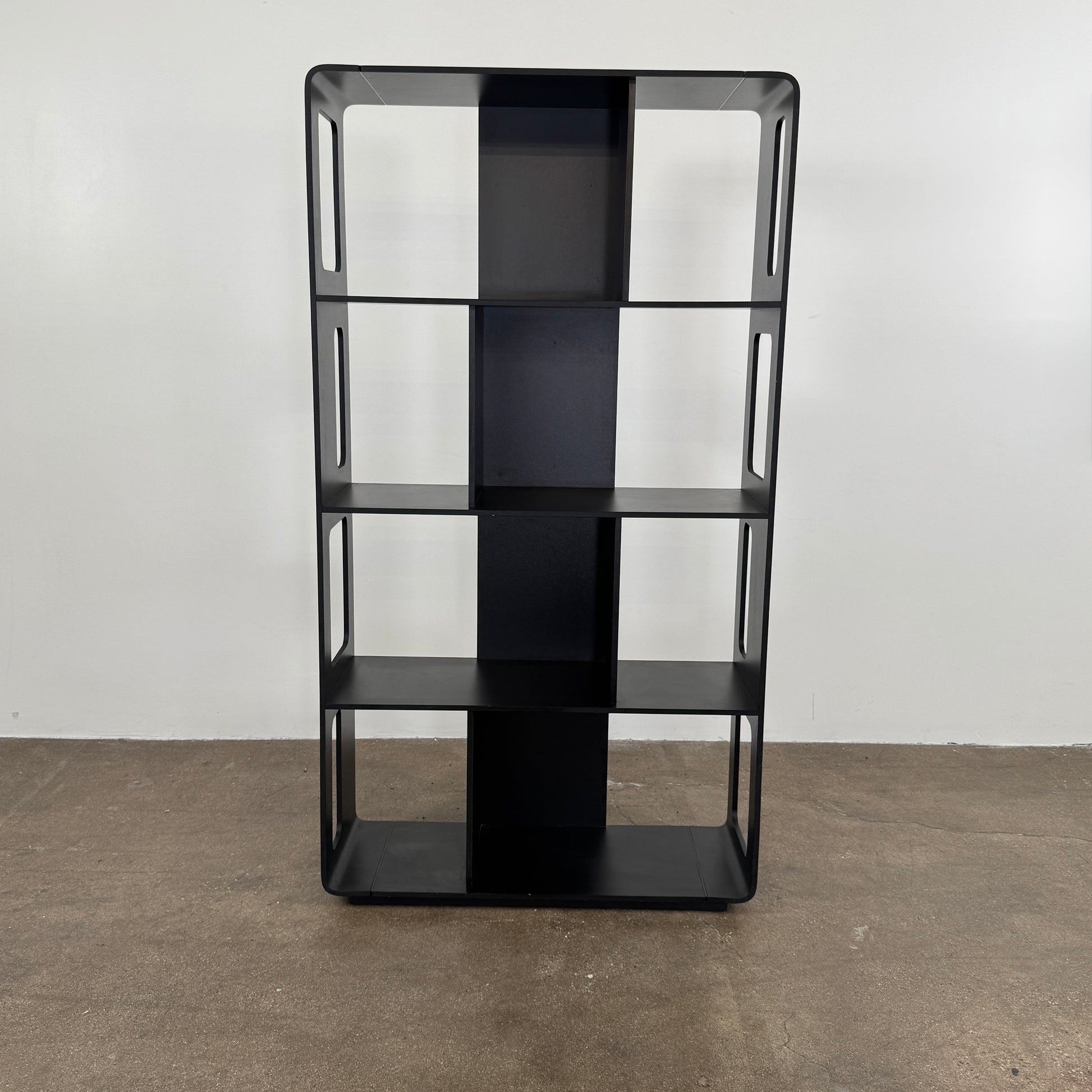 The B&B Italia Arne Bookcase Black Oak by B&B Italia is a modern open-frame bookshelf with five shelves and rectangular side cutouts, inspired by the Arne design, shown against a plain white background.