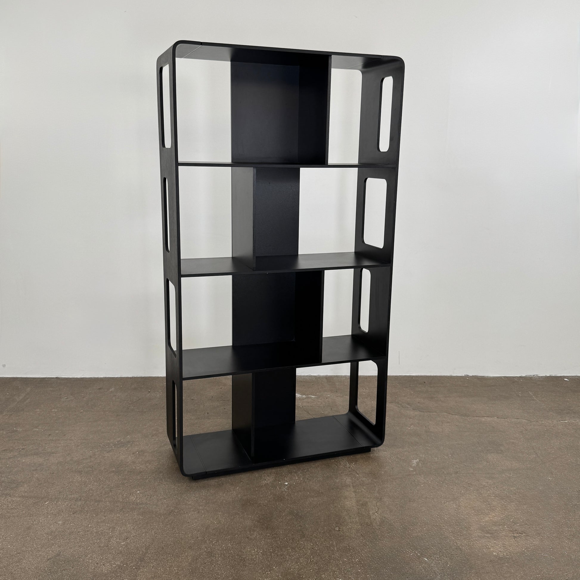 The B&B Italia Arne Bookcase Black Oak by B&B Italia is a modern open-frame bookshelf with five shelves and rectangular side cutouts, inspired by the Arne design, shown against a plain white background.