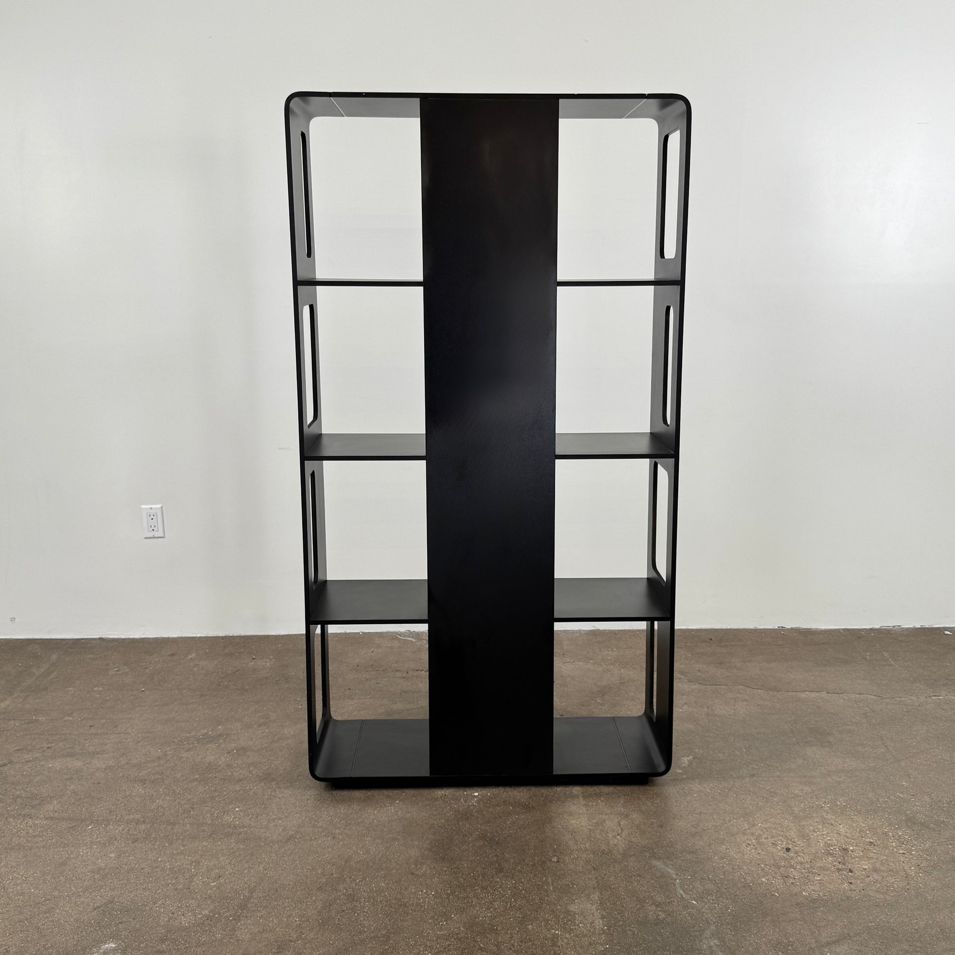 The B&B Italia Arne Bookcase Black Oak by B&B Italia is a modern open-frame bookshelf with five shelves and rectangular side cutouts, inspired by the Arne design, shown against a plain white background.