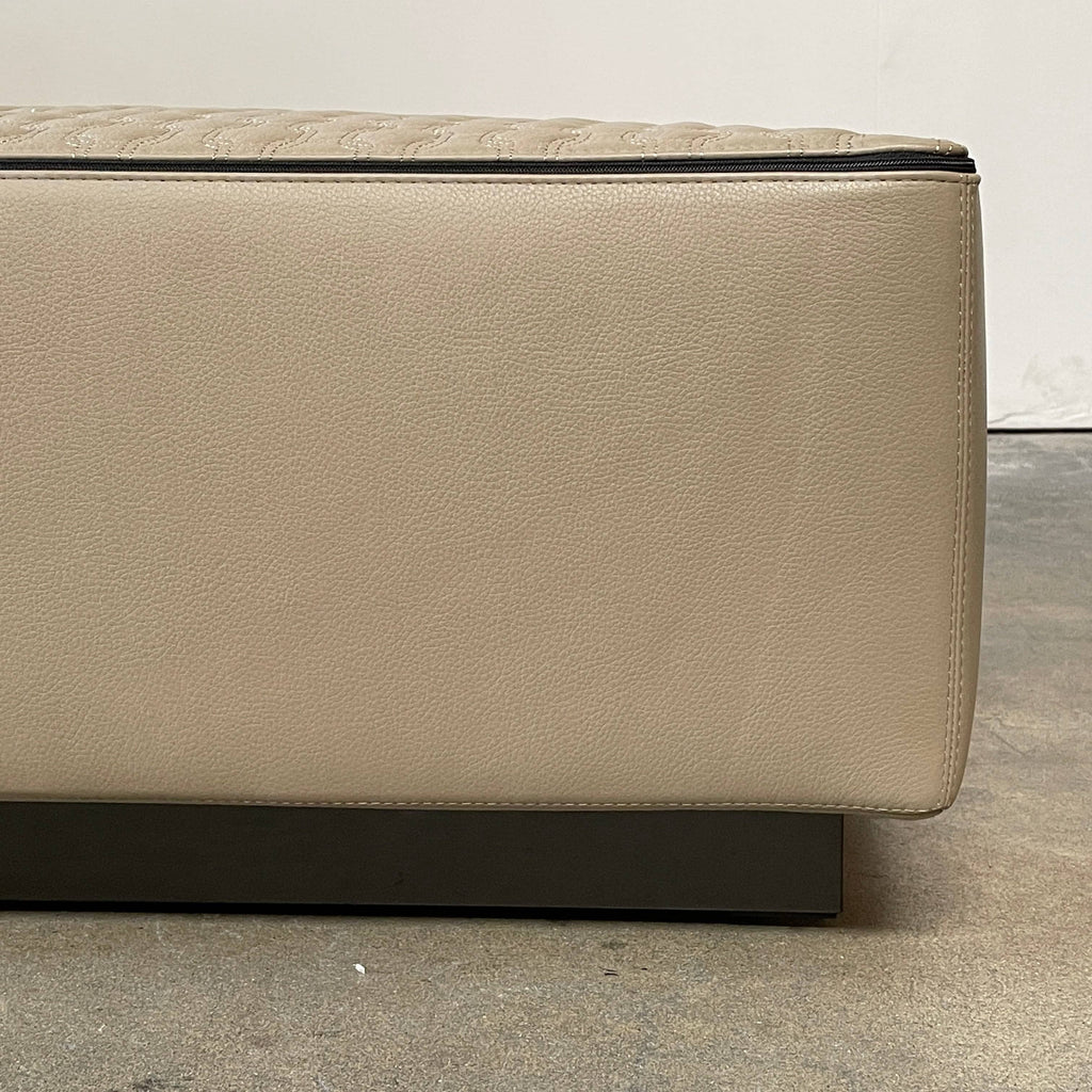 A Minotti Yang Leather Ottoman with a sexy zipper detail on a white background.