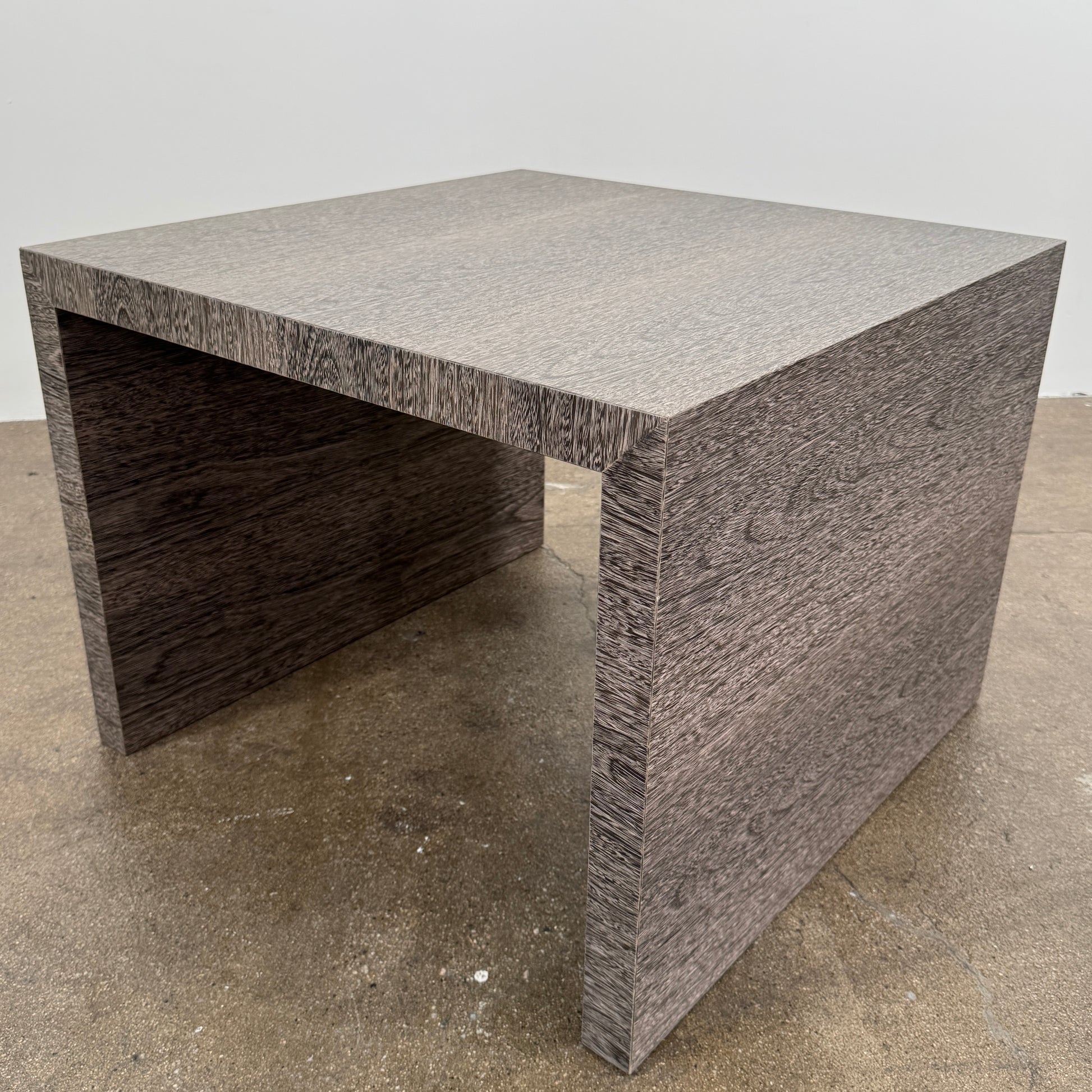 The Maxalto Arke Side Table by Maxalto is a square Sucupira wood accent table with a minimalist design, thick legs, and an open space beneath, shown against a plain white background.